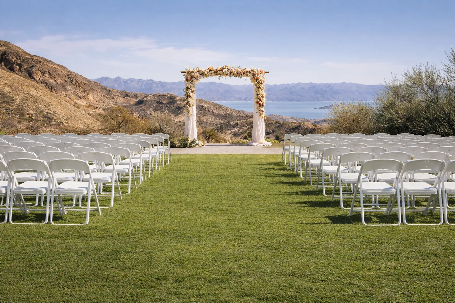 Outdoor wedding ceremony setup with white chairs and arch overlooking Lake Mead in Boulder City, Nevada.