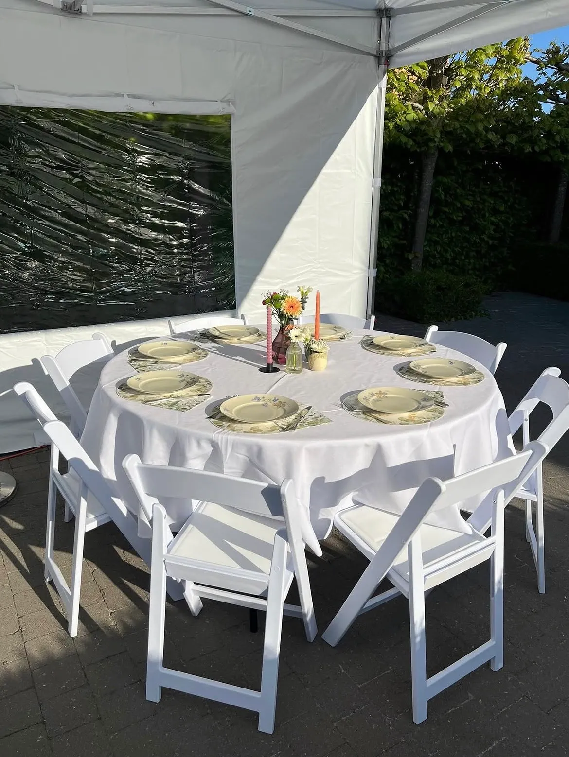 Feestelijk ingerichte vouwtent met ronde tafels, stoelen en terrasverwarming in West-Vlaanderen