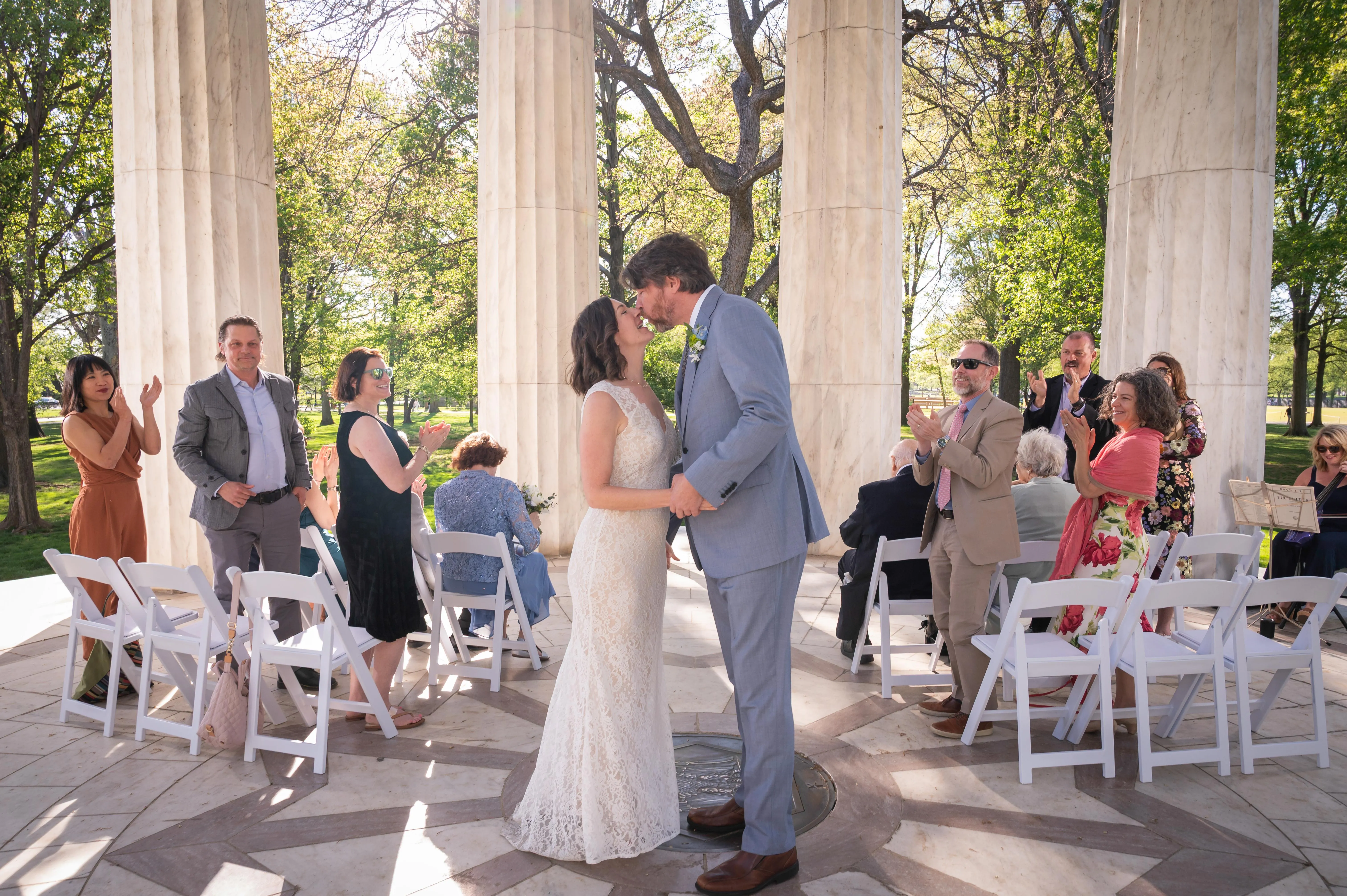 Wedding ceremony with white garden chairs and rental tables