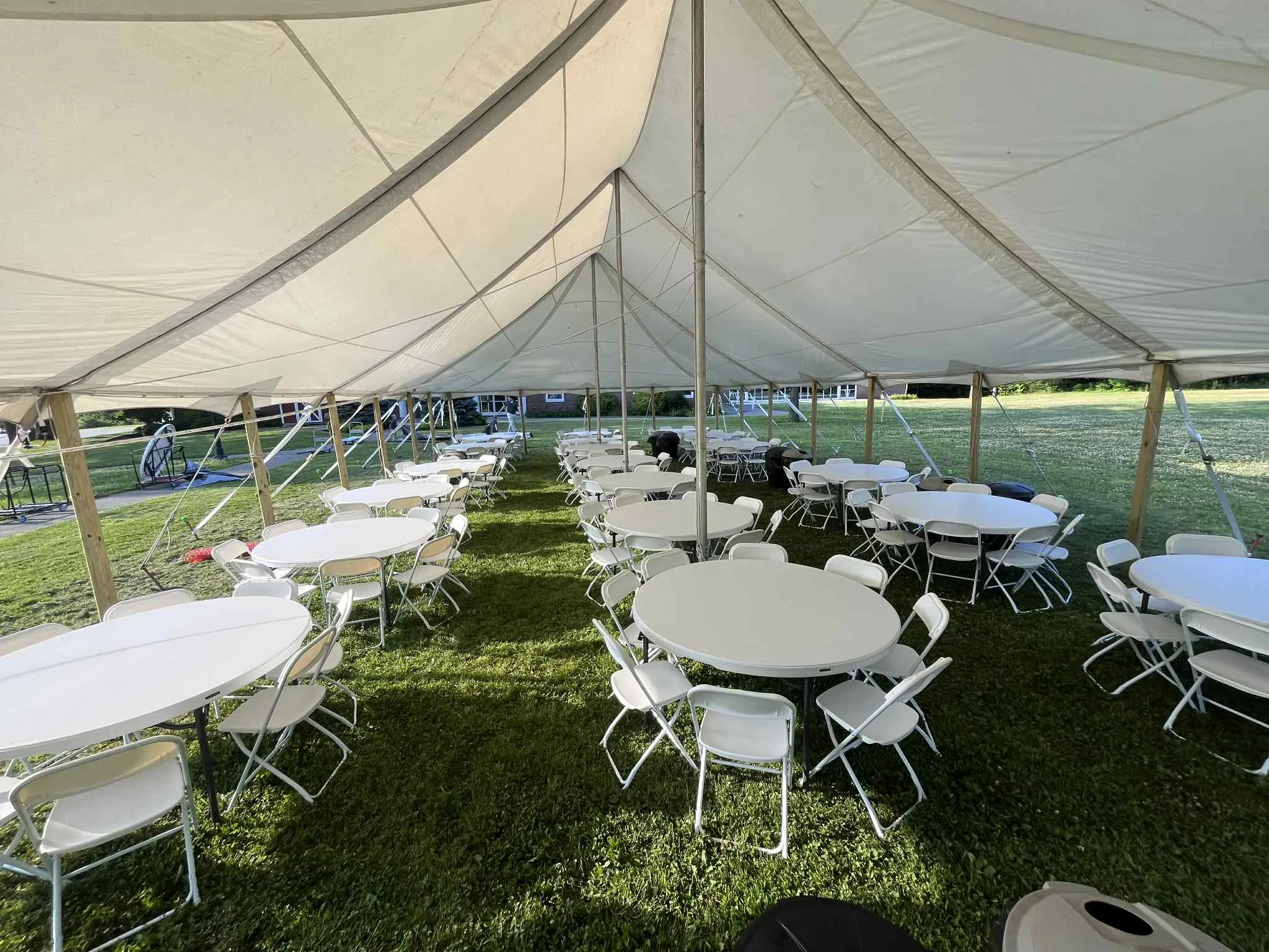 Round tables and chairs under a 40x60 pole tent