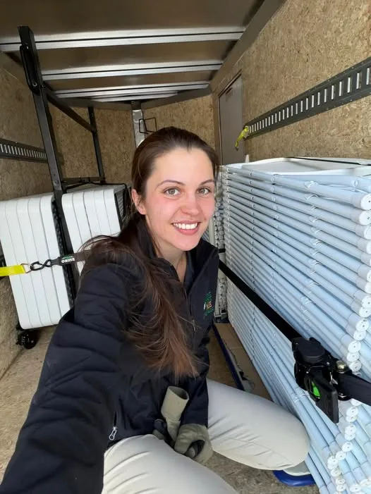 Becca, the owner, poses with tables and chairs