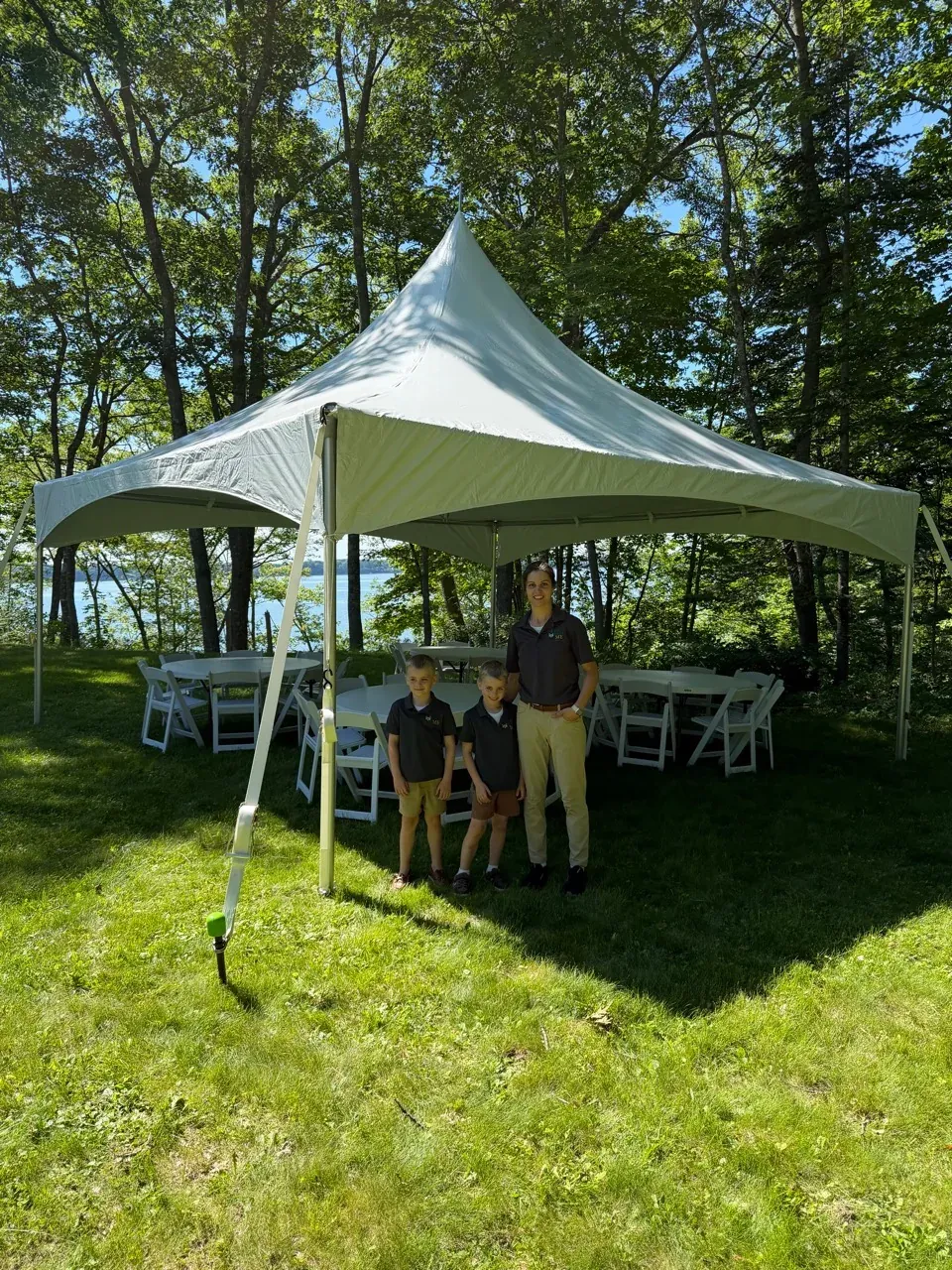 Becca and kids setup and event with a 20x20 high peak frame tent, tables, chairs down by the water