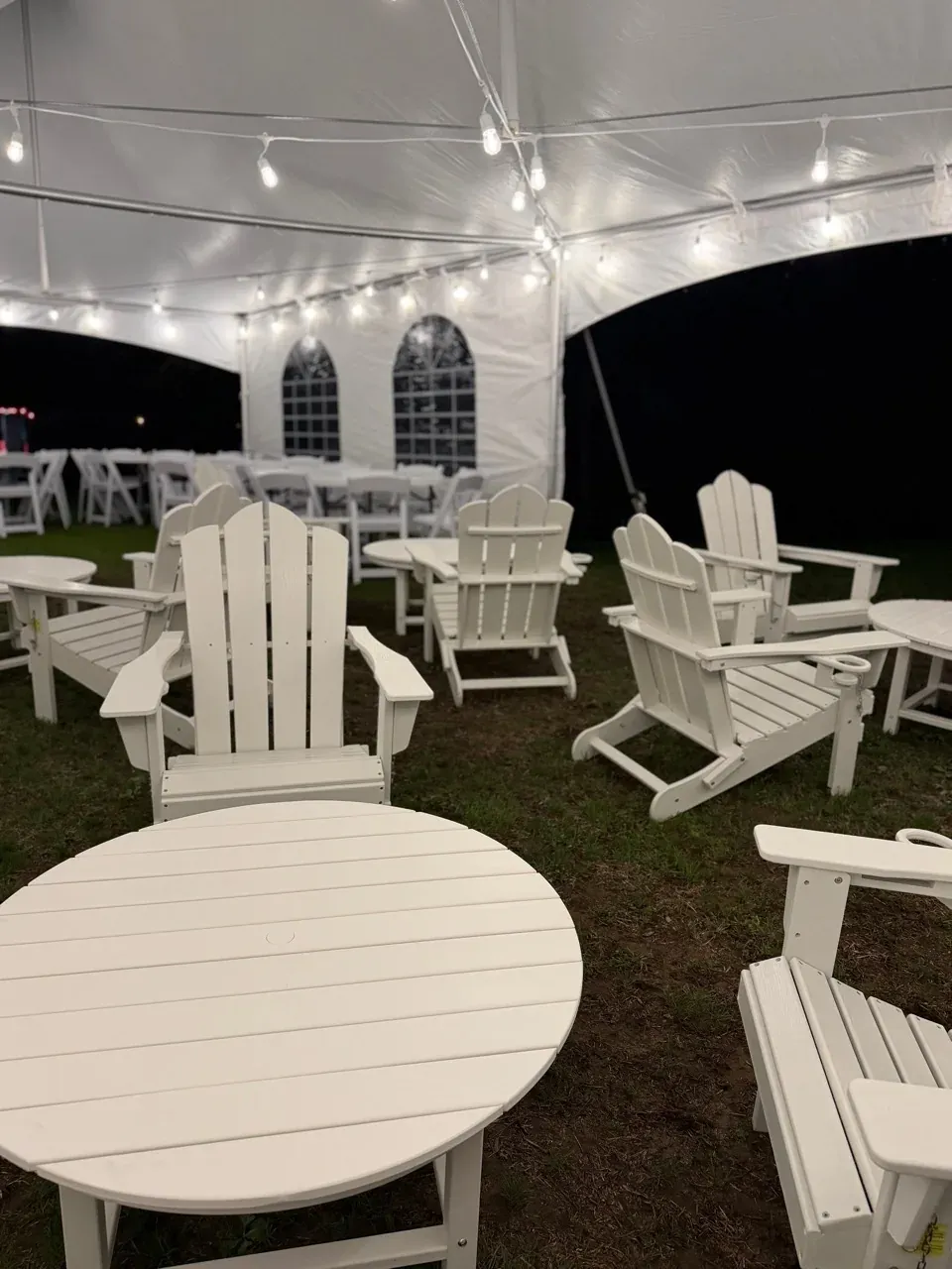 Adirondack chairs setup under a tent for a wedding rental in Leeds