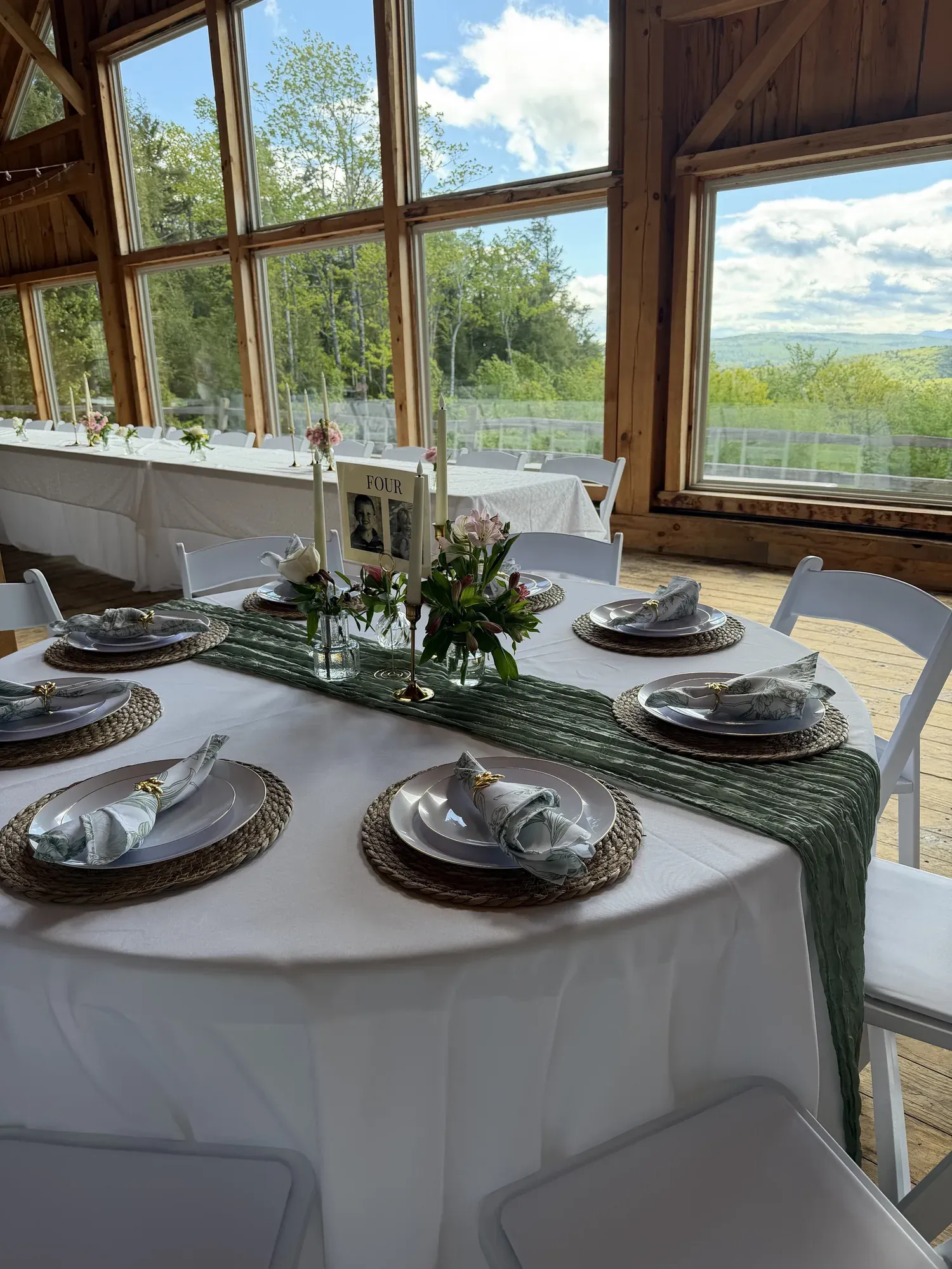 Wedding table setup with center pieces, plates and chargers, and padded resin chairs