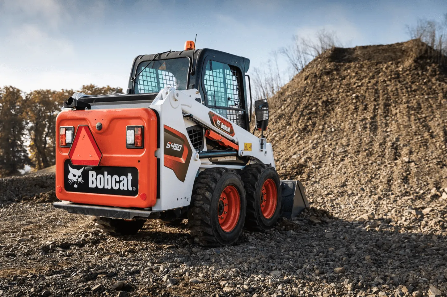 Bobcat S450 skid steer loader moving dirt on a construction site