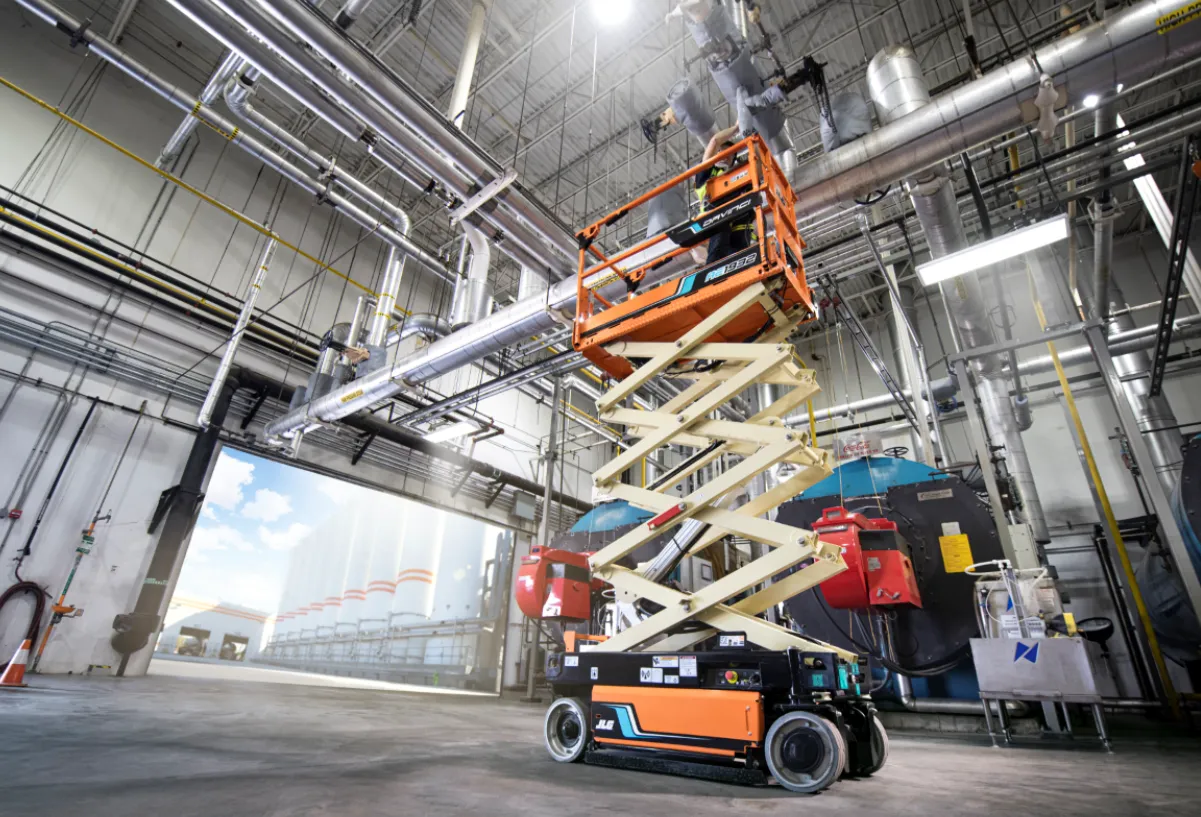 Scissor lift moving hoisting people on a construction site