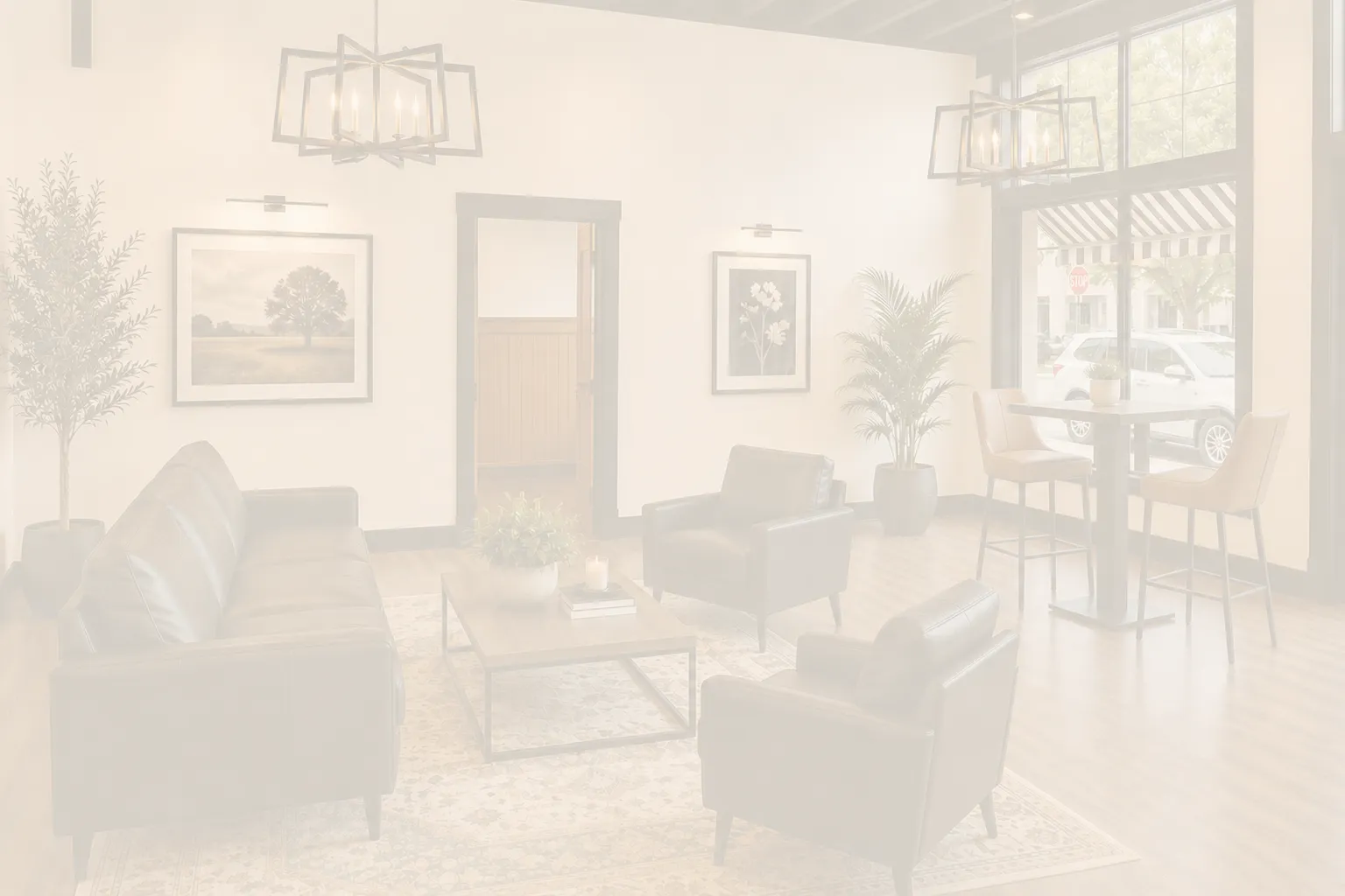Good Day Venue lounge seating area with black leather furniture, warm lighting, and downtown Higginsville charm.