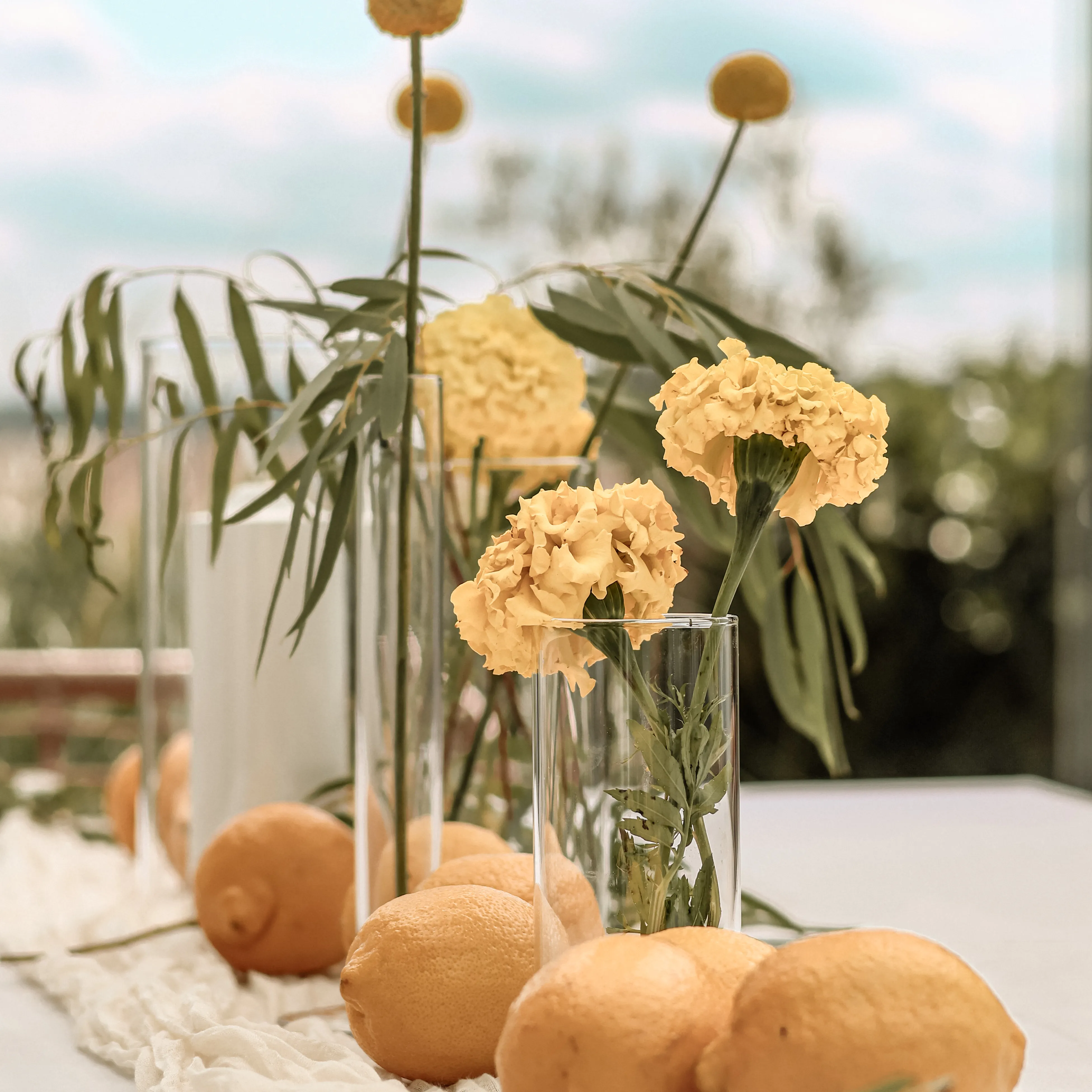 Minimalistische Tafeldekoration in Creme mit Musselin-Läufer und einzelnen Blüten