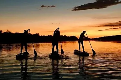 Person enjoying a stand-up paddleboard on the calm waters of Narrawallee Inlet.