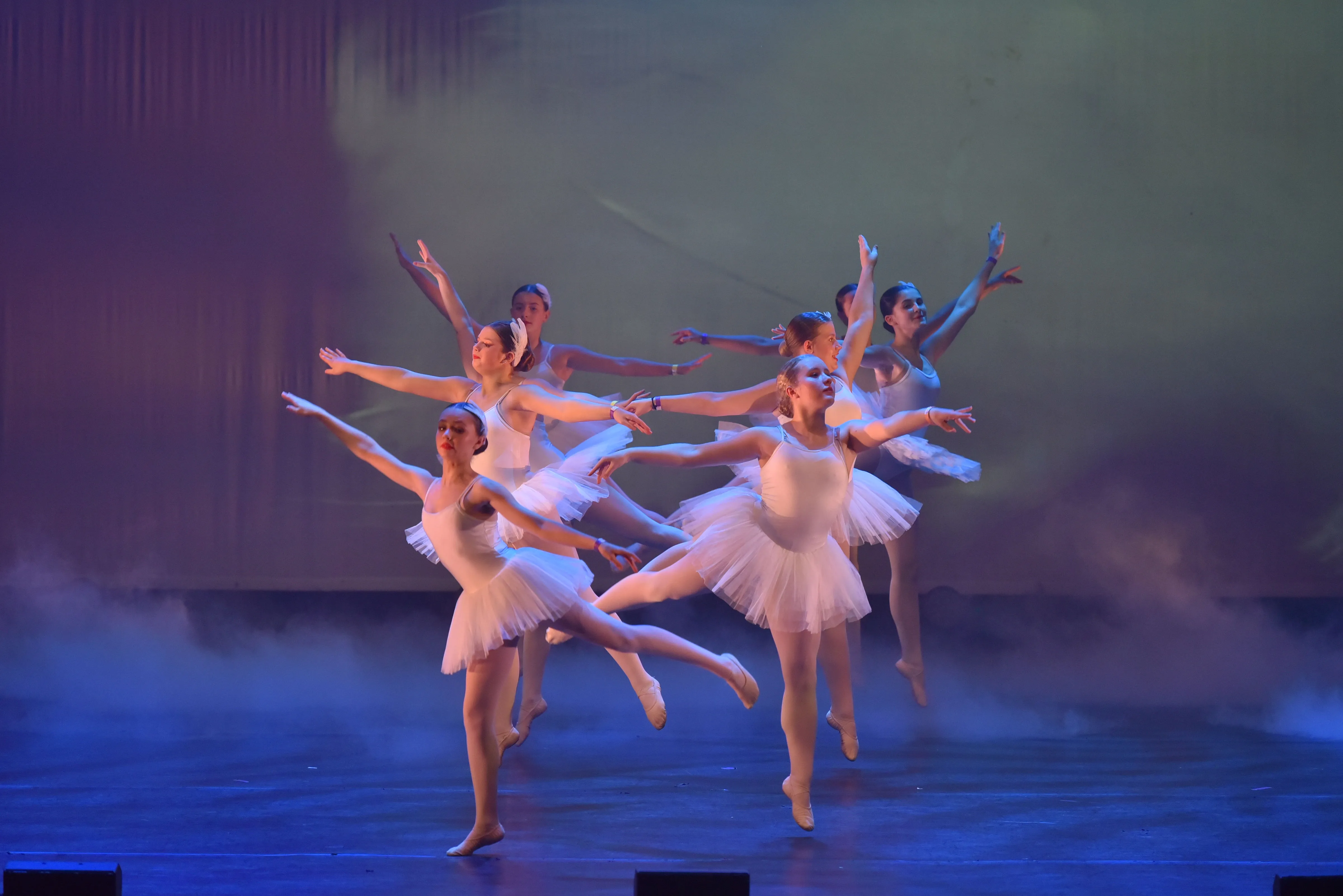 Two female dancers performing on stage in taupe costume 