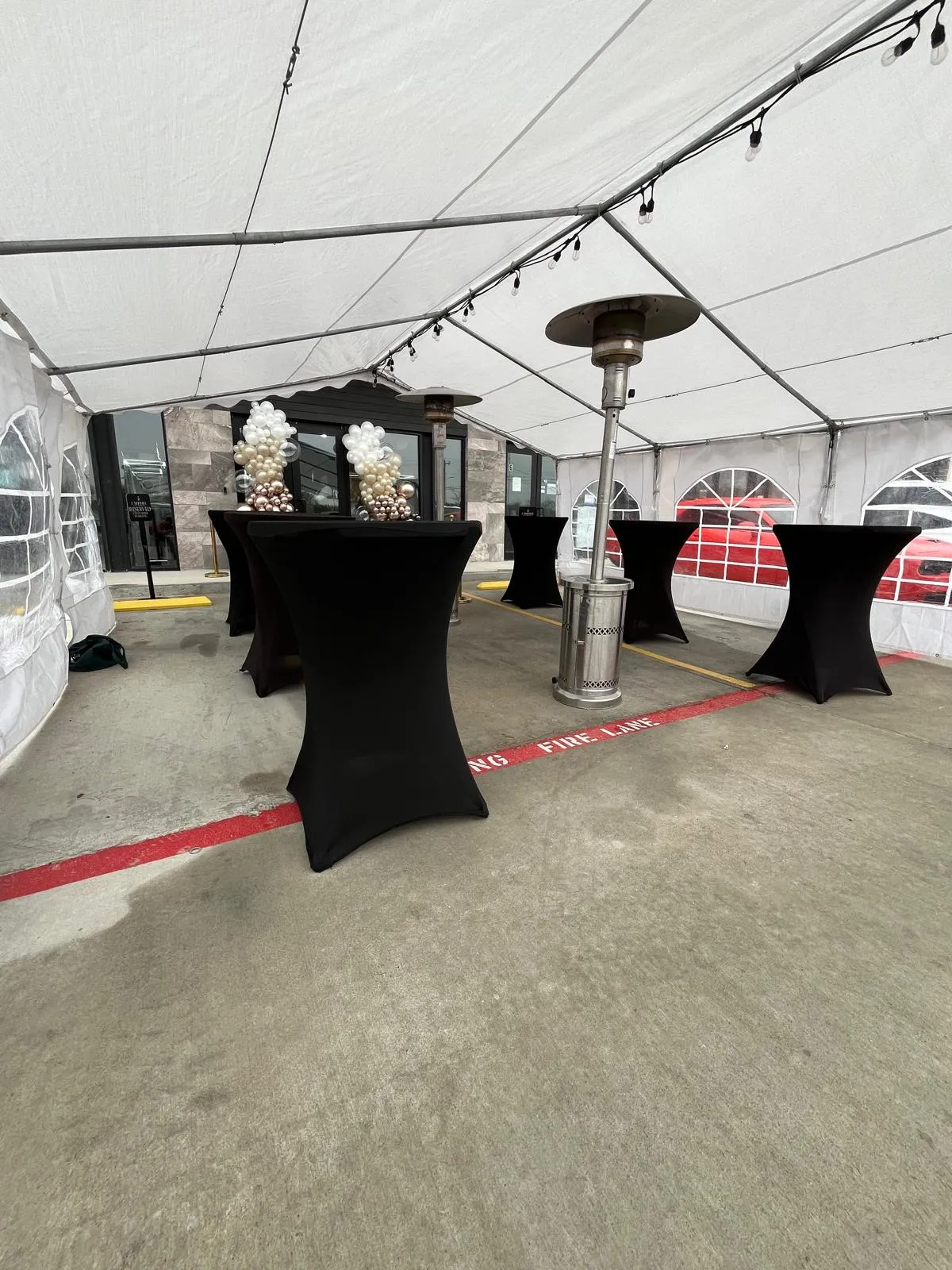 White resin chair and banquet table rental setup under a party tent in Laredo, TX.