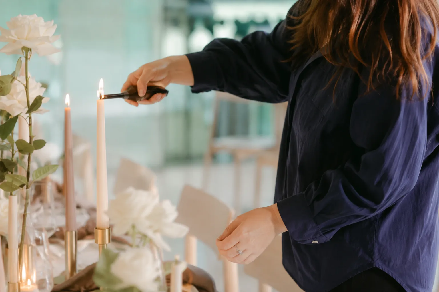 Behind the scenes candle lighting and tablescape styling with blush taper candles and white florals by Miss Events Melbourne