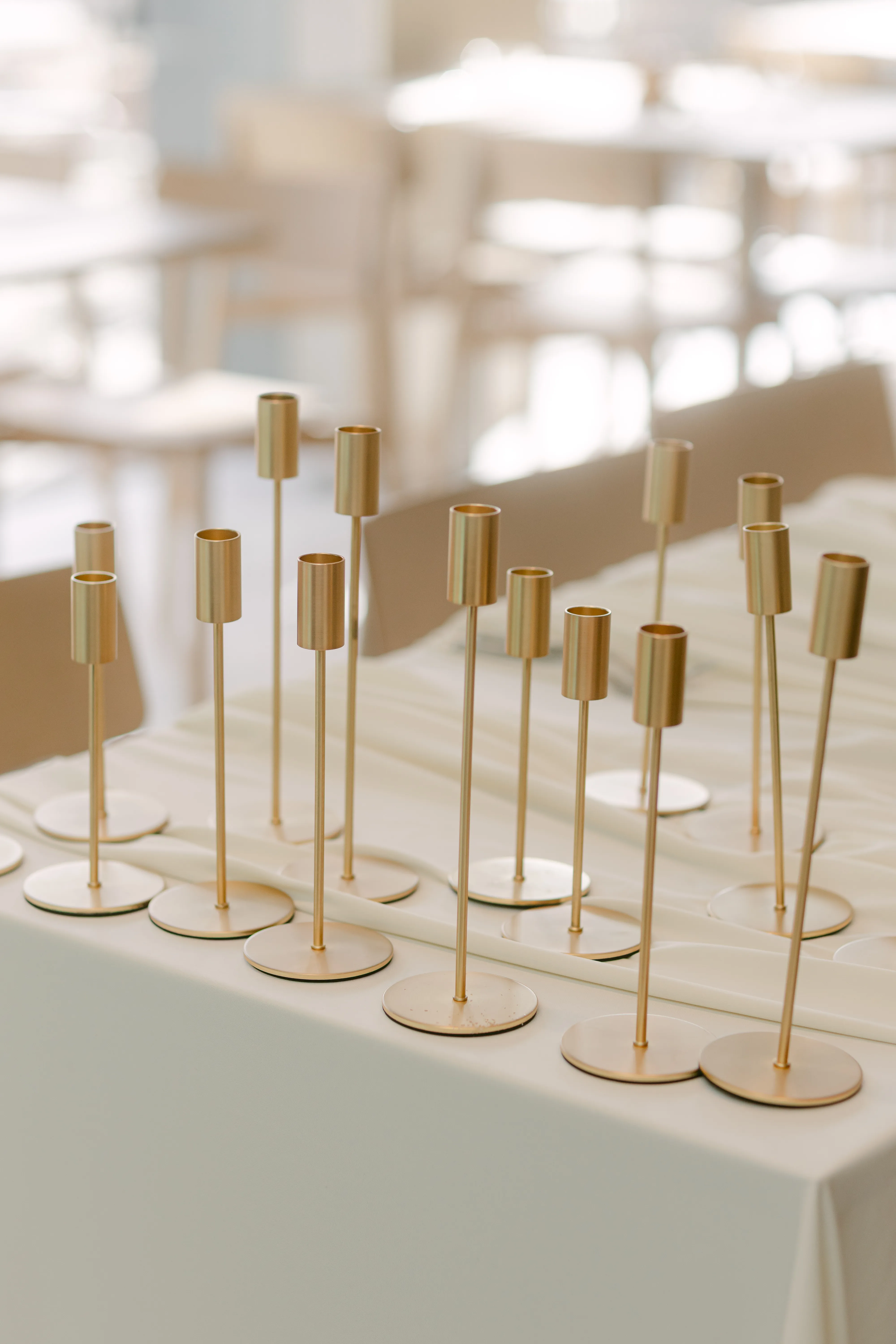 Behind the scenes of wedding styling, with candlesticks prepared for candle placement as the tablescape comes together.