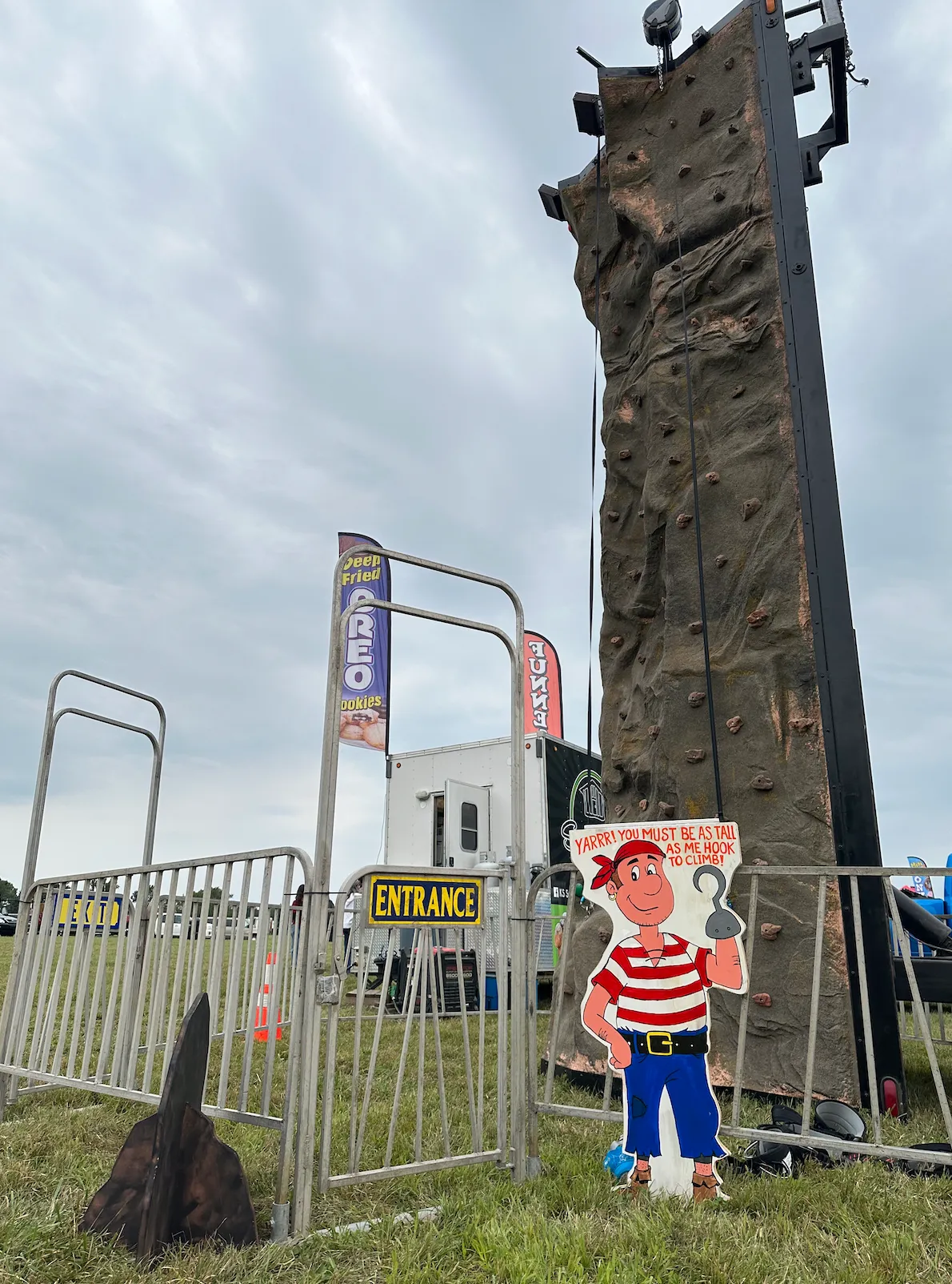 Large, colorful rock wall rental with various holds and obstacles, set up outdoors and ready for climbers of all ages and skill levels.