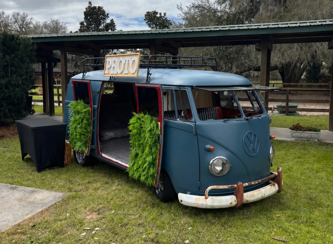 A blue 1958 Volkswagen Split-Window Panel Bus set up as a photo booth with decor.