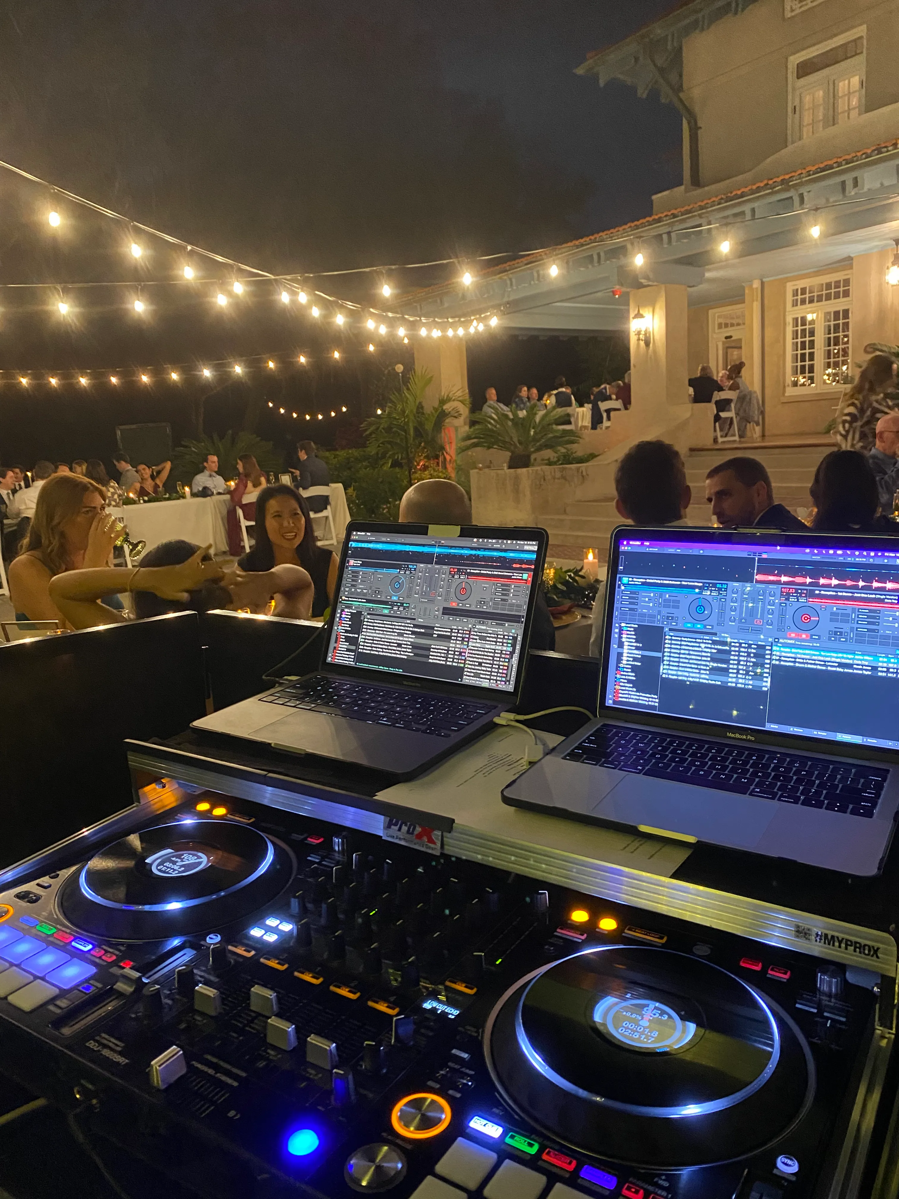 A DJ set up and an event reception blurred in the background