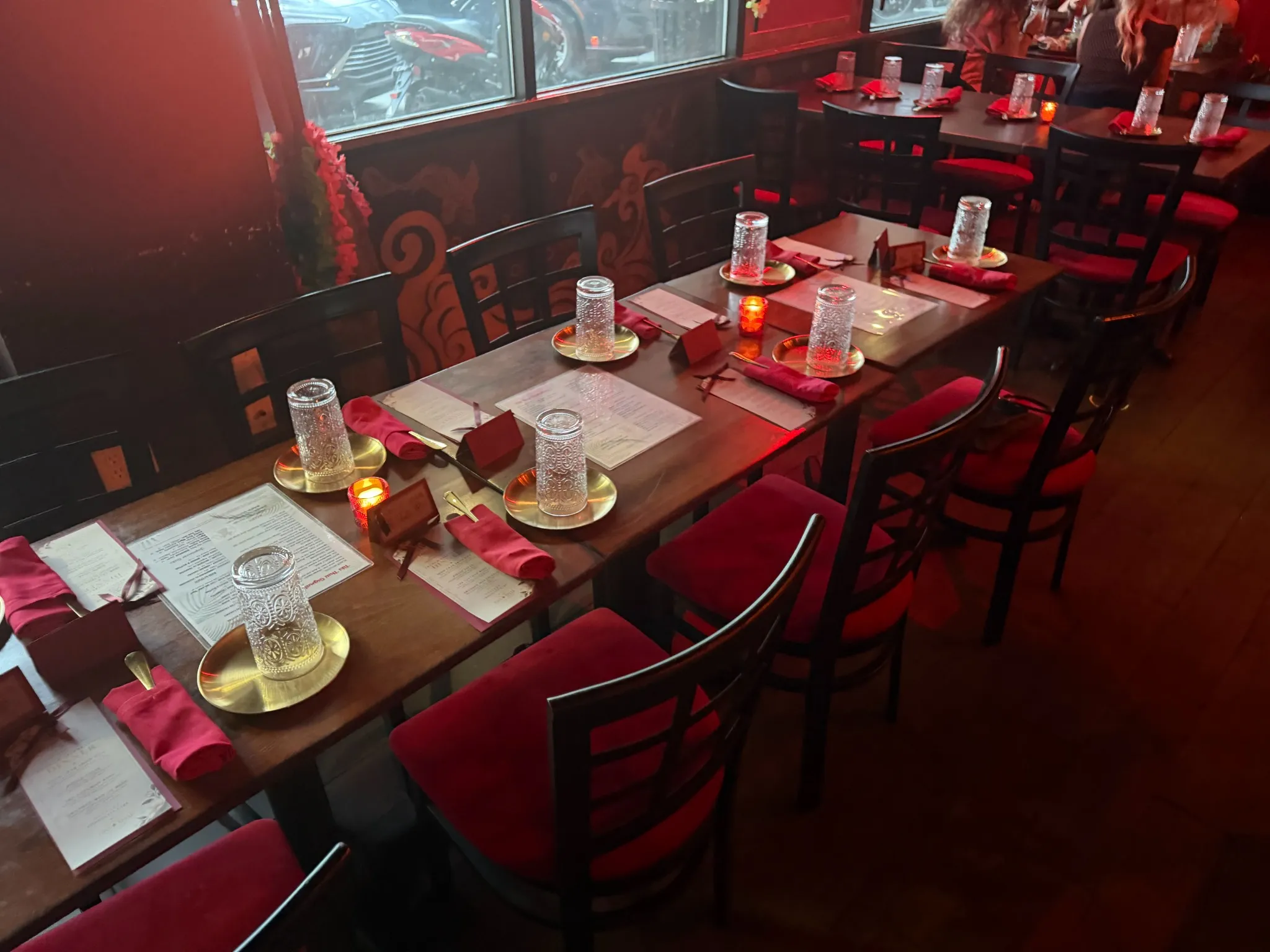 Dinner tables with red chairs set by Brown Butter Moments