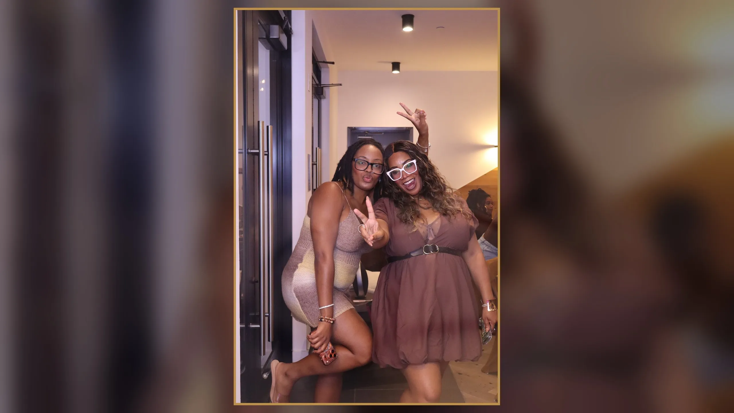 Two guests smiling together at a Brown Butter Moments selfie mirror photo booth