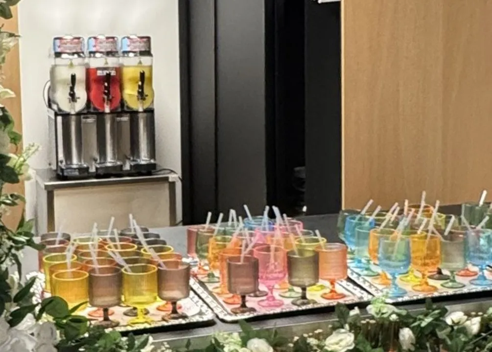 Slushmaskin og fargerike glass klare på en bar til sommerfest