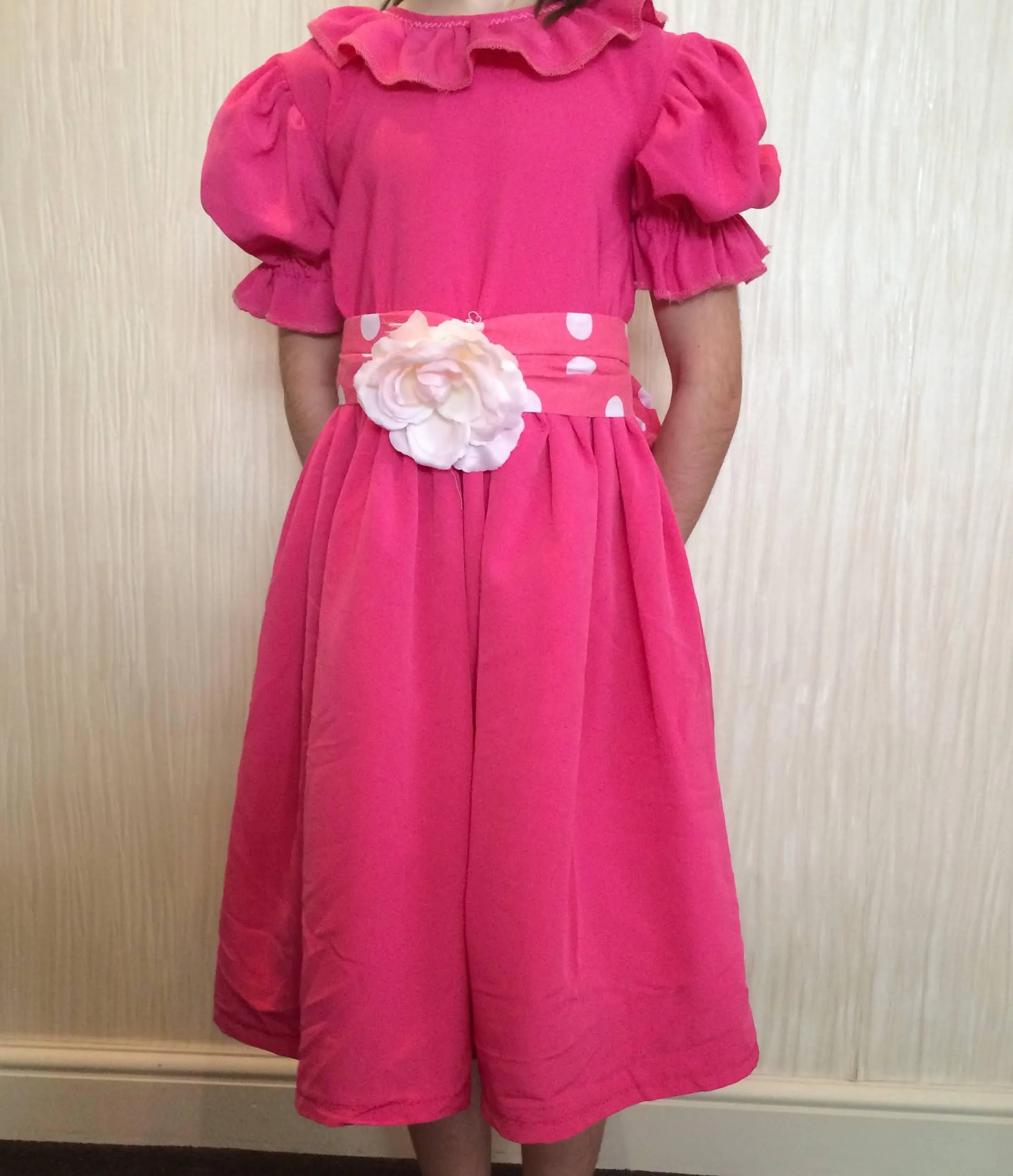 Pink Victorian style dress with polka dot waistband and flower centre