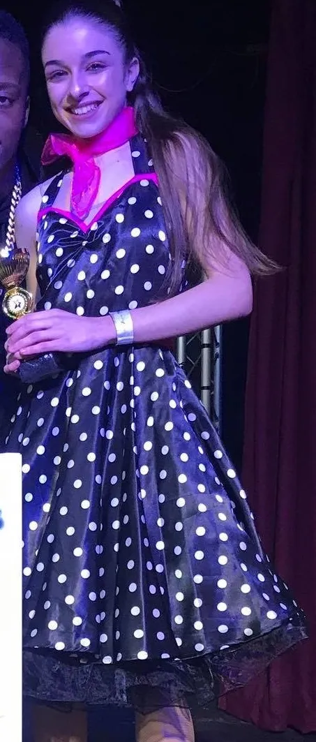 Black and white polka dot halter neck dress with pink waistband and neck scarf