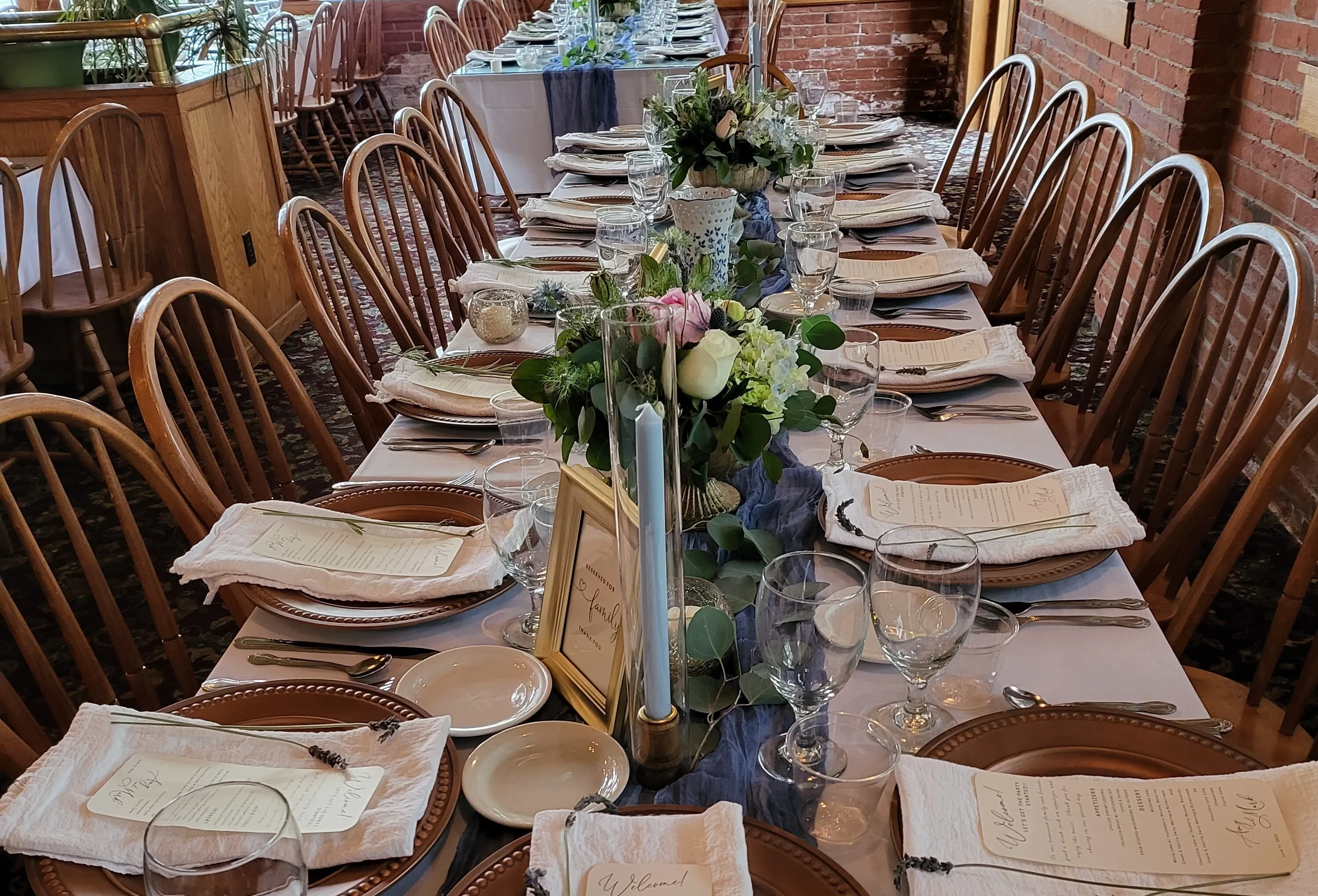 Tall clear cylinder vase has wood candleholder with gold trim
