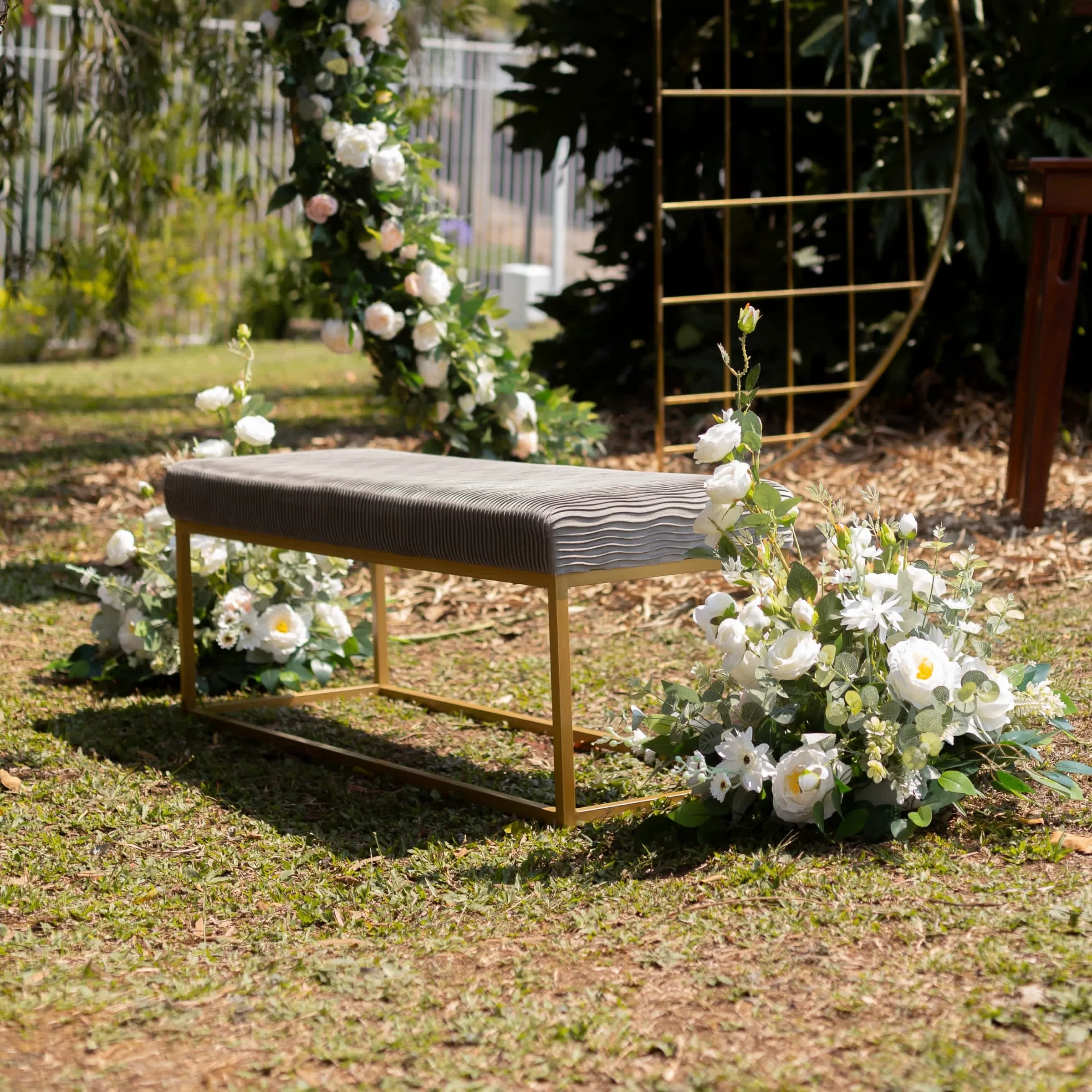 Banca dorada con dos arreglos florales