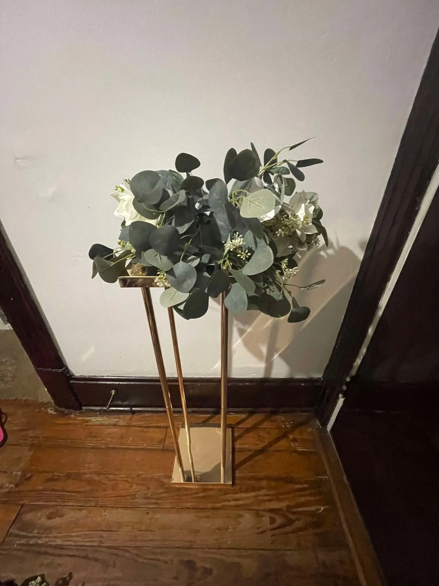 White flowers and greenery on stand