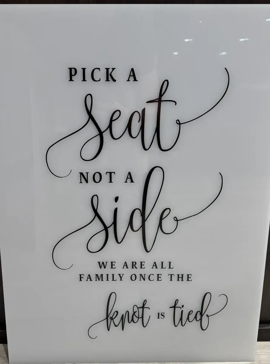 Pick a seat not a side, white acrylic sign
