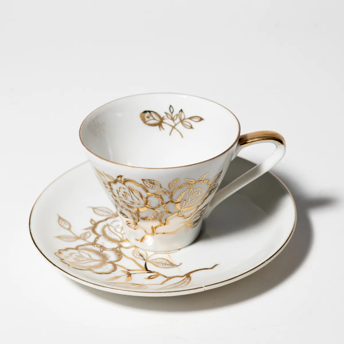 Cup and Saucer White with Gold Leaf Flowers Painted on it.