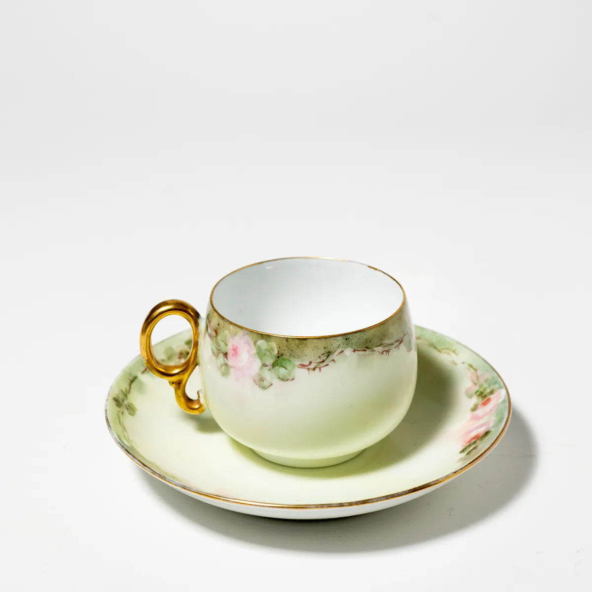 Dainty pink flower and green tea cup and saucer