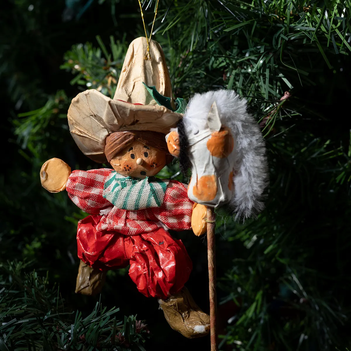 Christmas Tree Ornament: Vintage Child with red and green ranch attire and sombrero playing on a horse broomstick, Paper mache