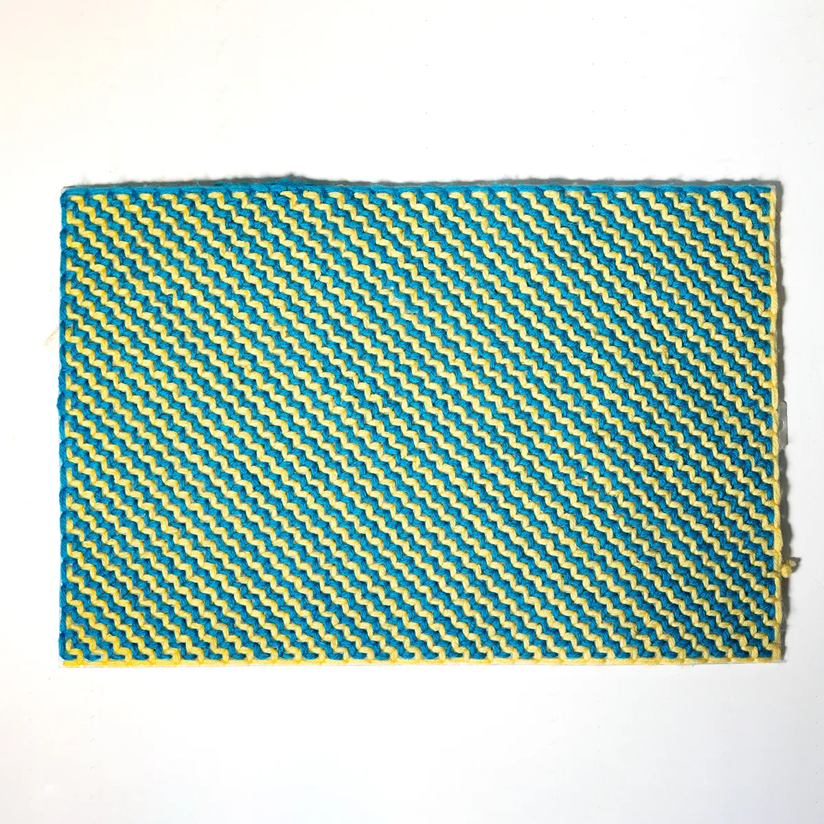 Retro Blue and White Surface with a zig zag pattern in yarn