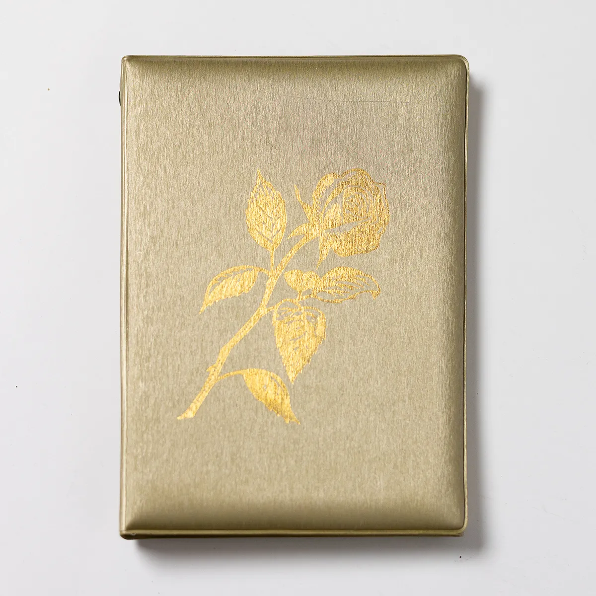 Beige Funeral Guestbook with a gold flower emblazoned on the cover. Used Guestbook