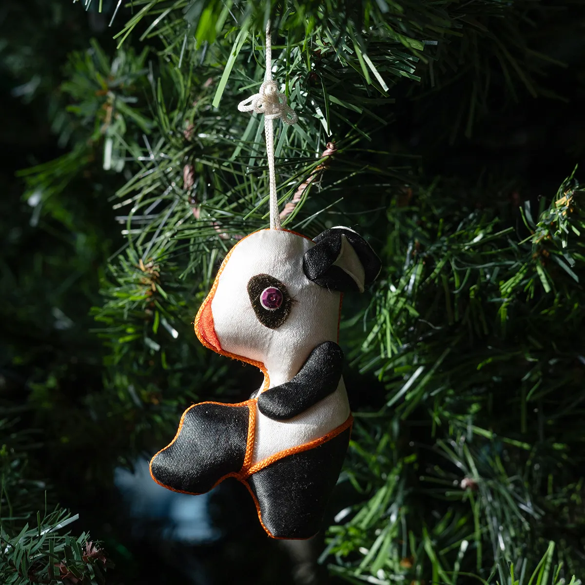 Christmas Tree Ornament: Black and White stuffed panda profile with orange trim and pink sequin eyes