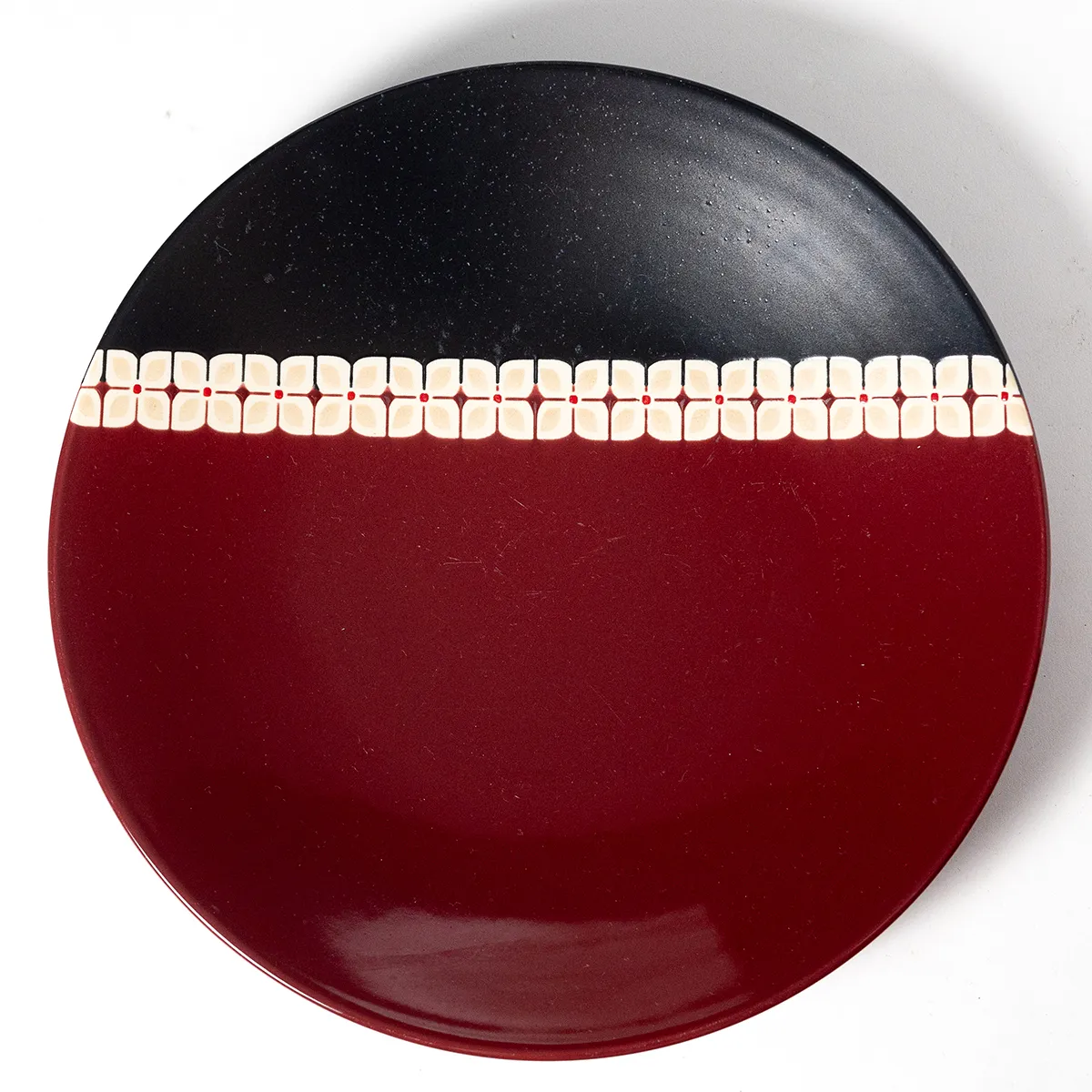 Maroon and Black Concave Dinner Plate with a Cream colored zipper Design