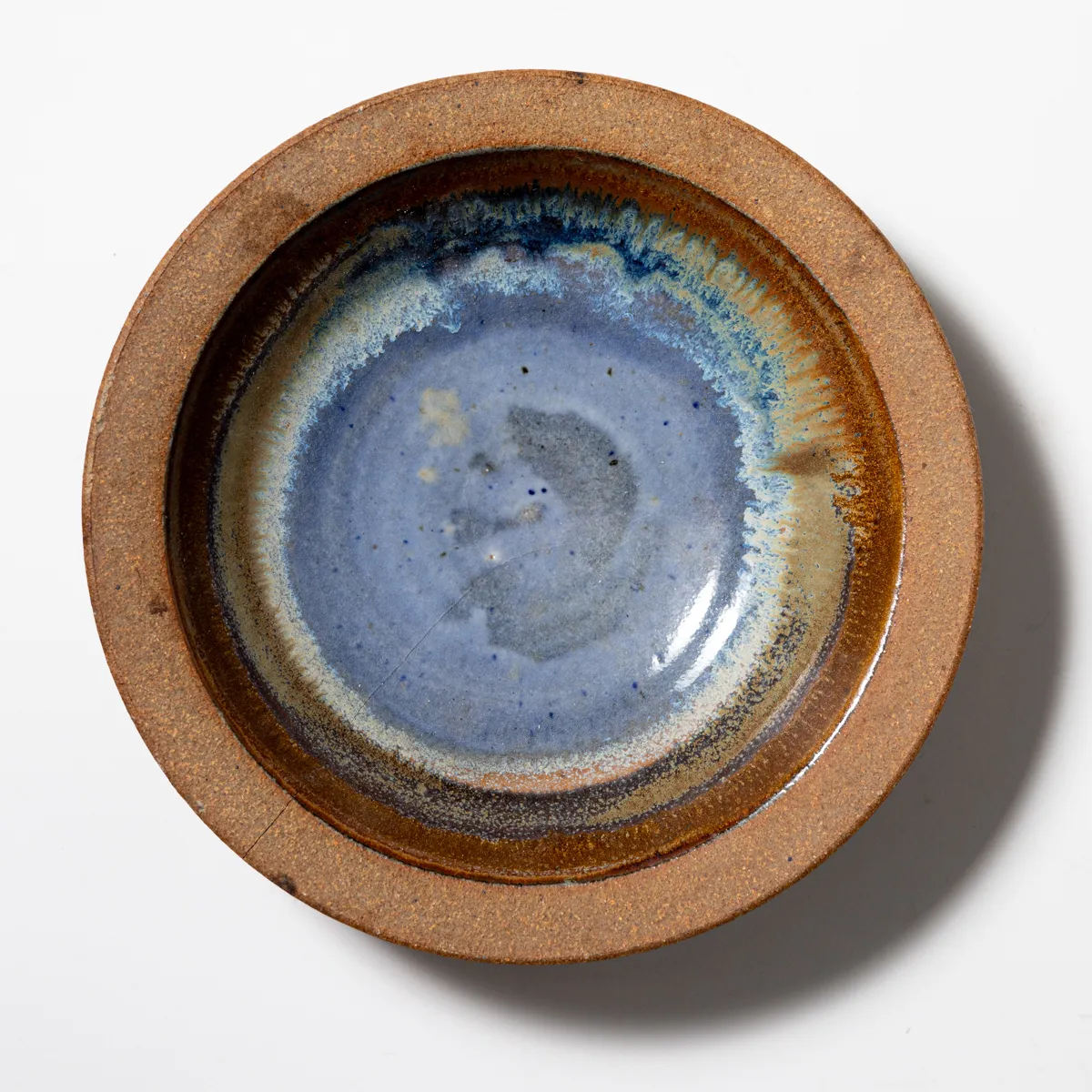 Vintage Soneware Art Pottery Bowl Natural Textured Raw unfinished Brown around the rim and Blue glaze in the center.