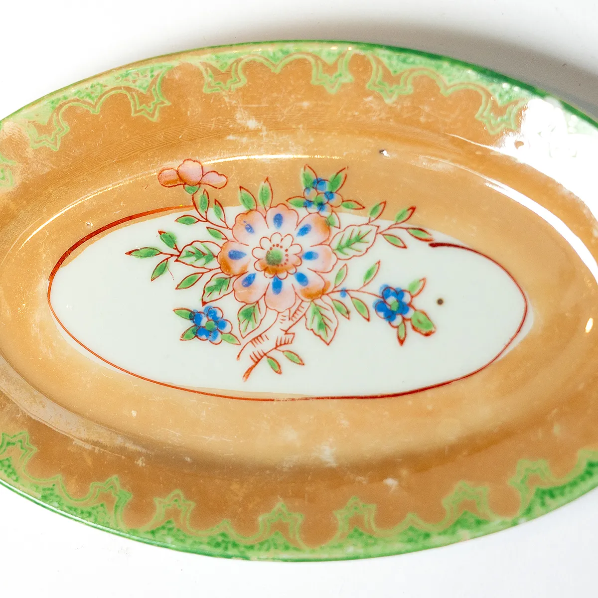 Orange Iridescent Oval Plate with Green detailed rim Hand Painted Flower in the center
