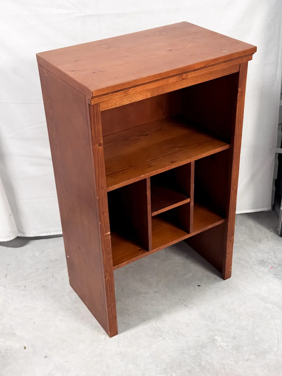wooden bookcase with a reddish-brown stain. odd uneven openings