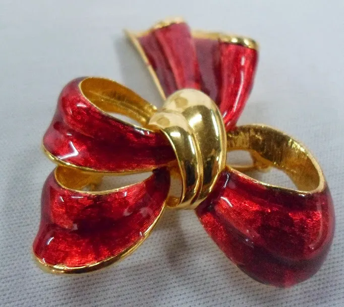 PRENDEDOR  MOÑO  ORO CON LACA ROJO 5 X 6 CM 