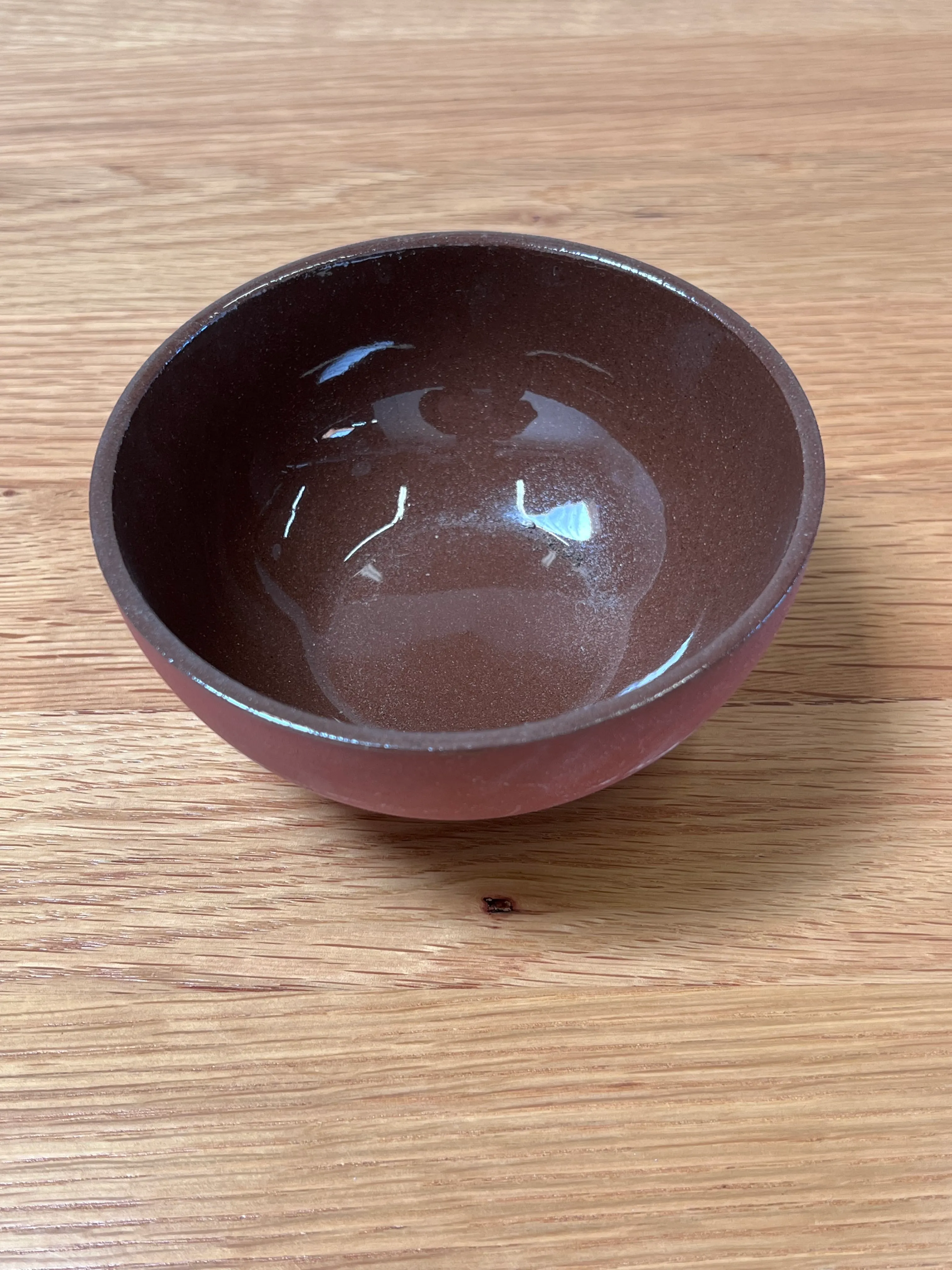 Small red clay bowl with glossy inside