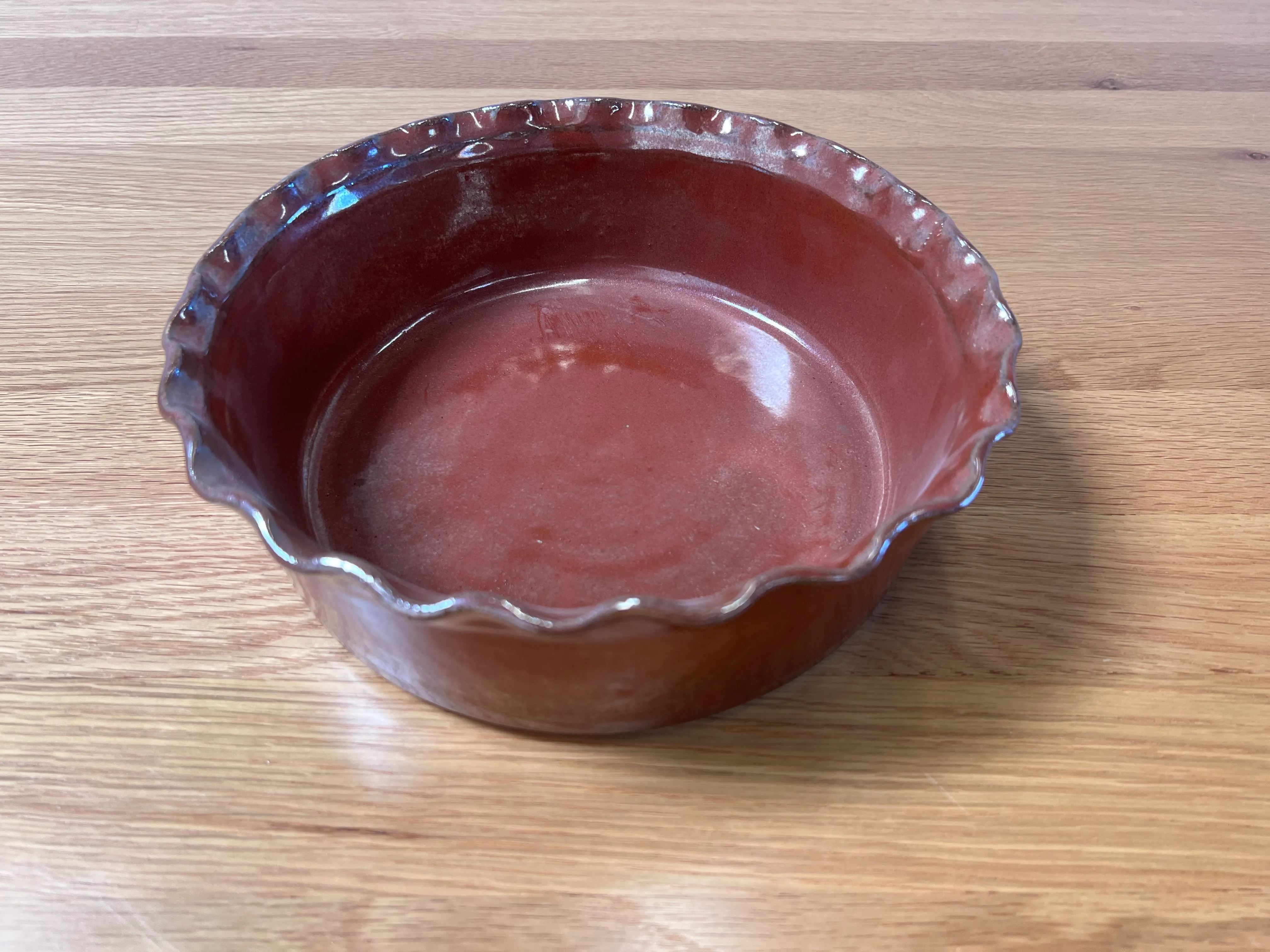 Large red serving bowl with scalloped rim