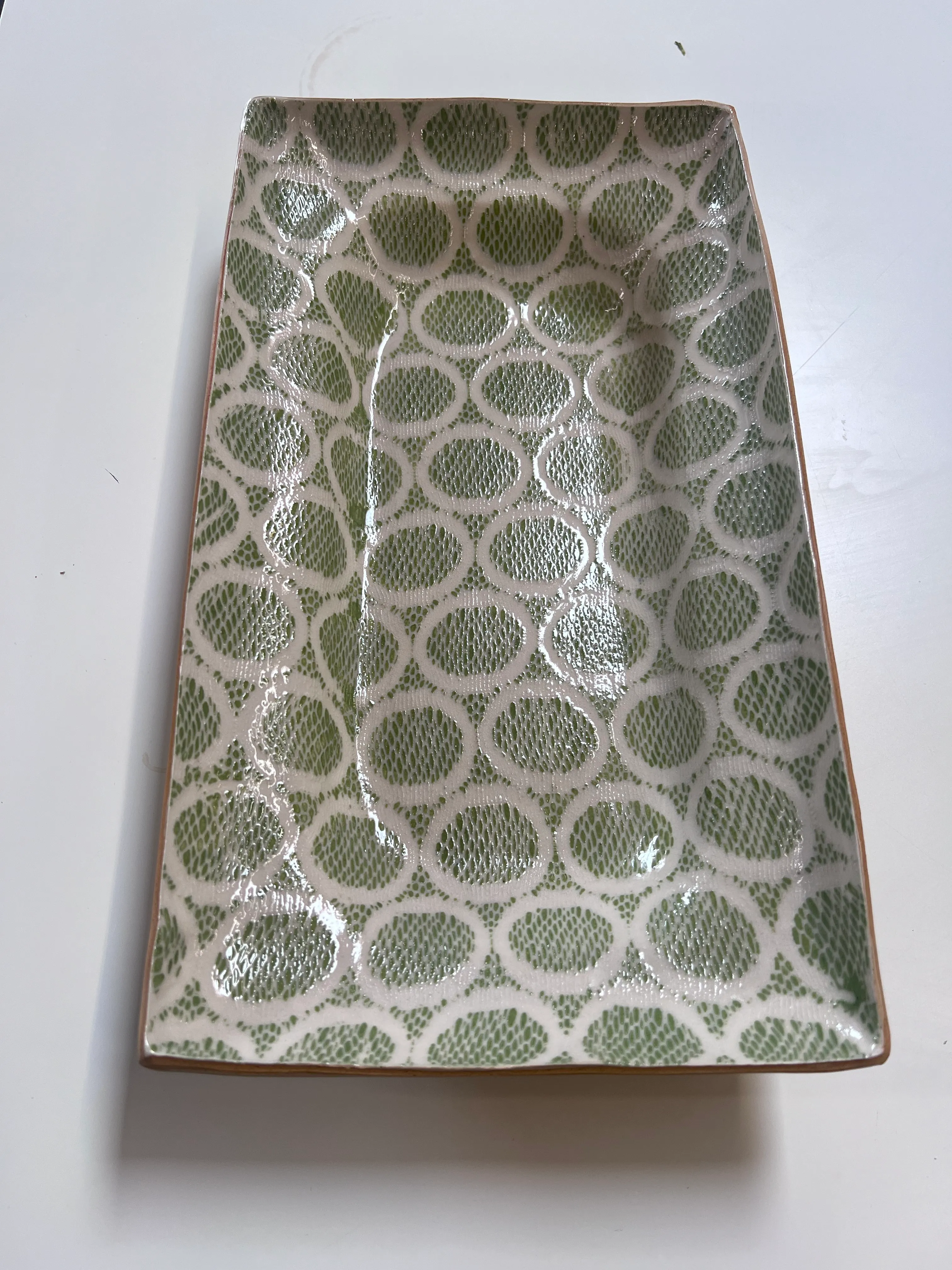 Green and white circular patterned serving dish