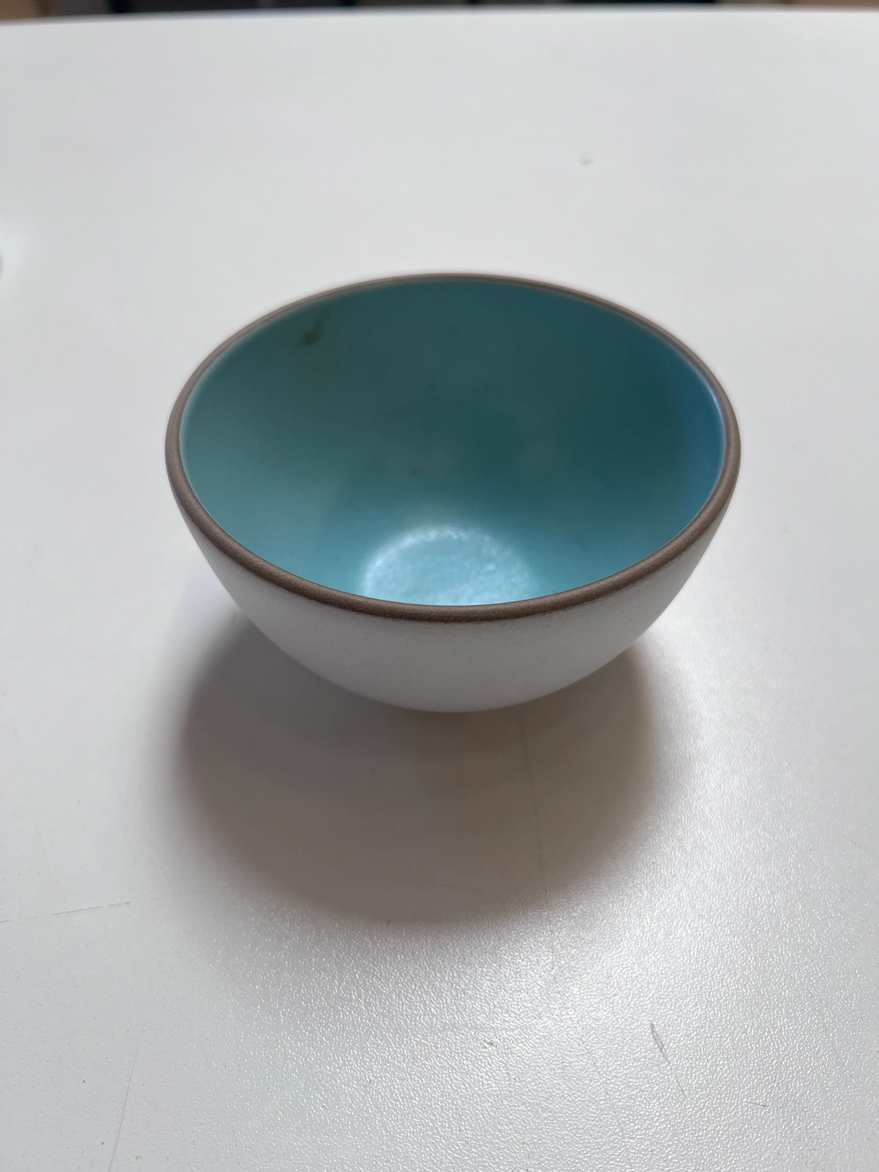 Grey bowl with aqua blue inside 