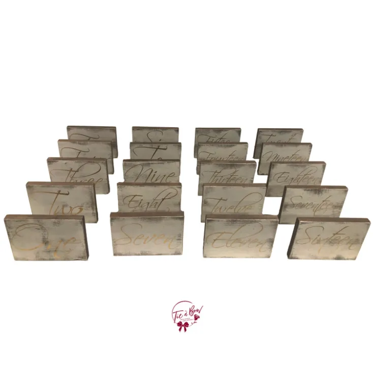 White Washed Rustic Wooden Table Numbers Written in Gold 1-20