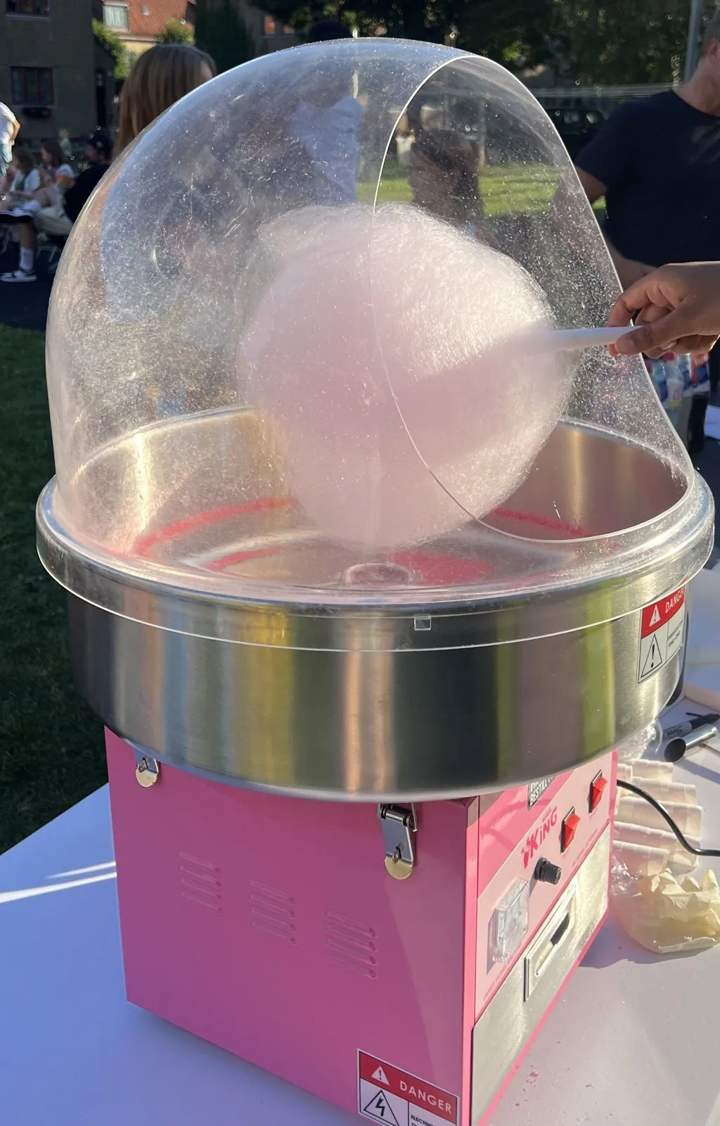 Sukkerspinnmaskin som lager sukkerspinn på en hagefest