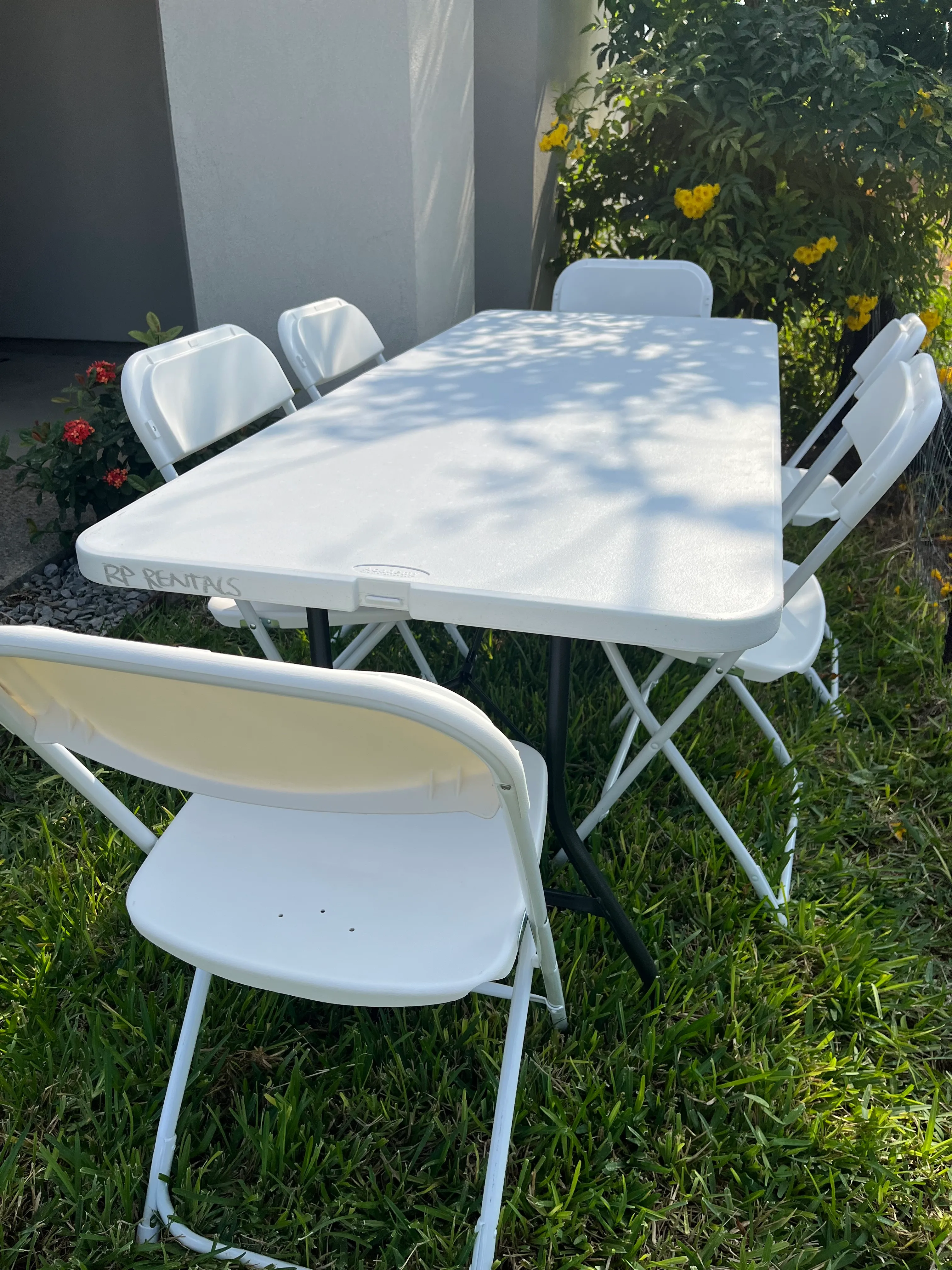 6 ft table and 6 white plastic chairs