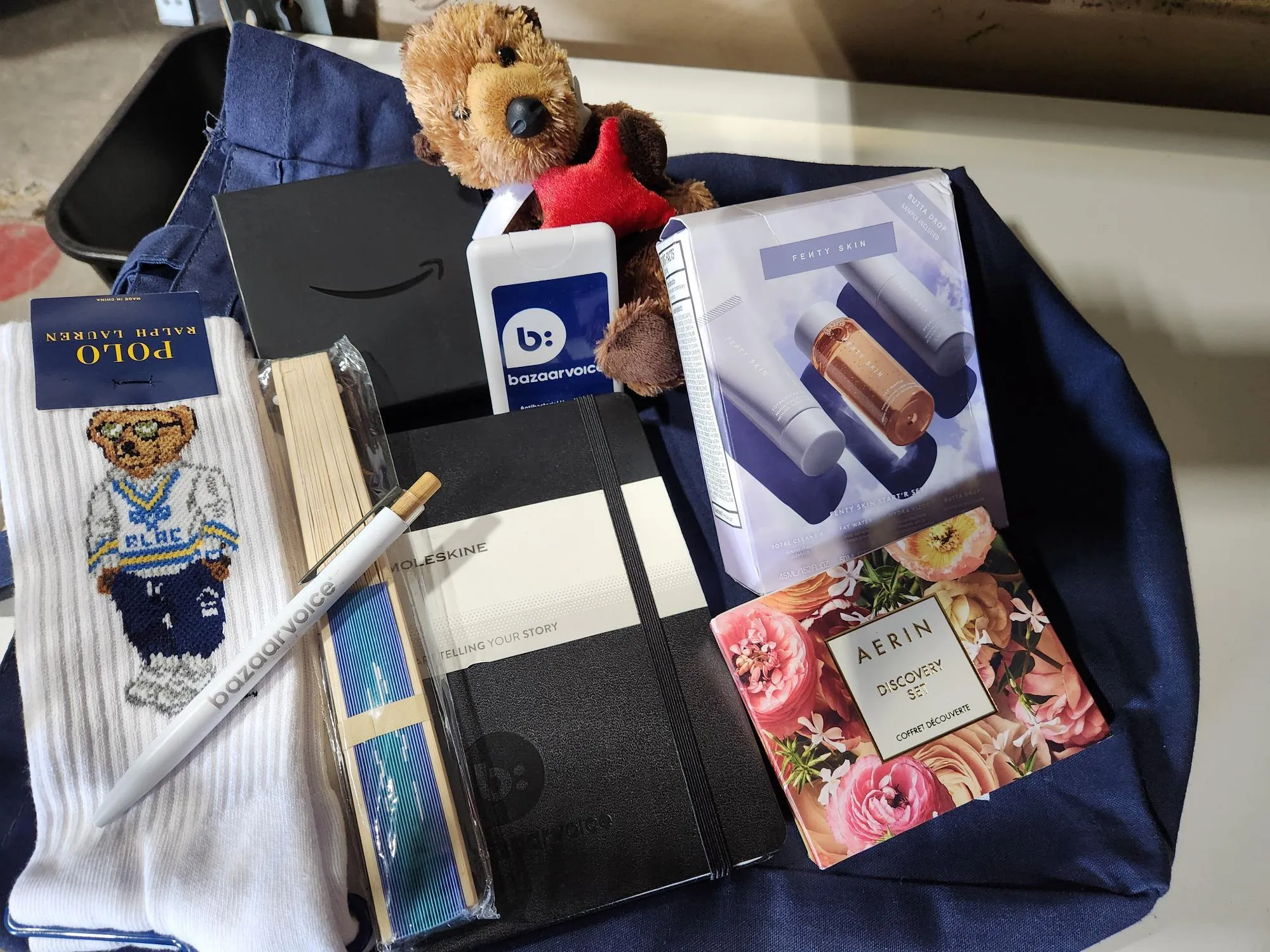 Bag with (Amazon GF, Otter, Socks, Fan, Pen, Notebook, AERIN discovery set, Fenty Skin, hand sanitizer)