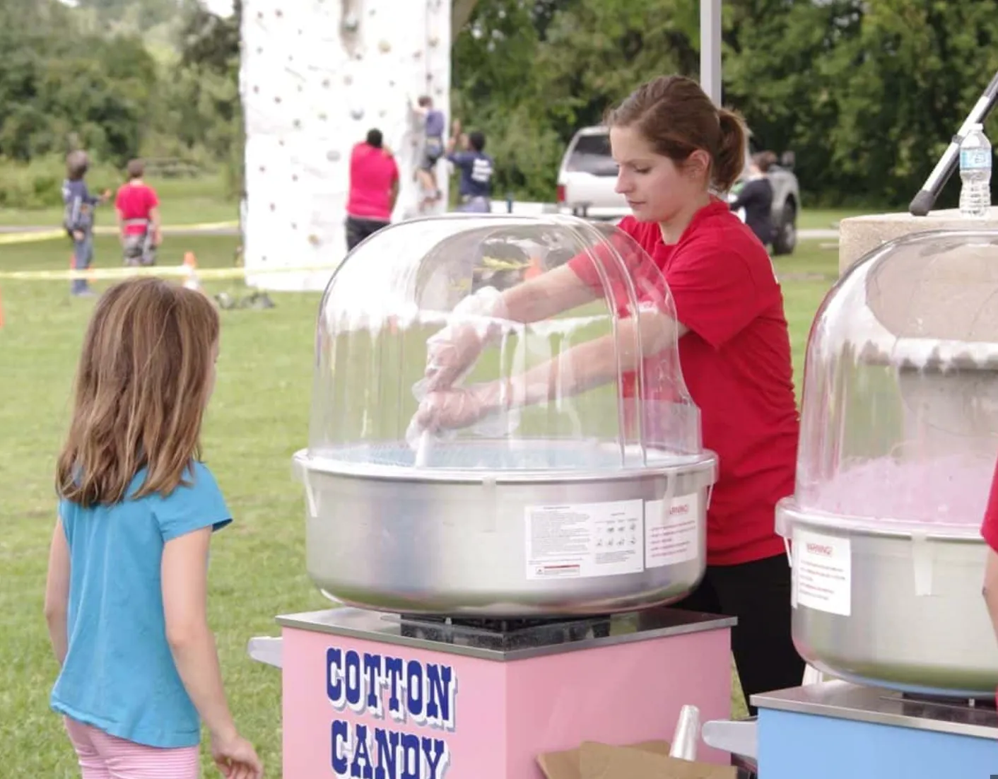 Image of a girl spinning cotton candy at a carnival guy party rentals event