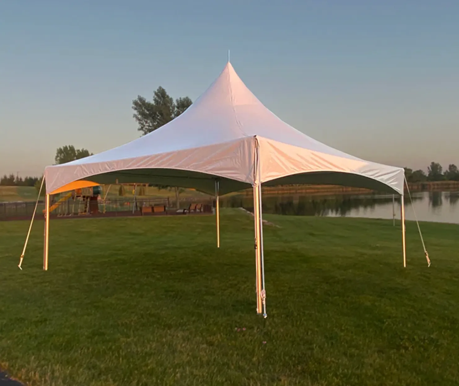 Large white event tent with tables, chairs, lighting, and event equipment set up for an outdoor celebration in Northeast Kansas by Carnival Guy.